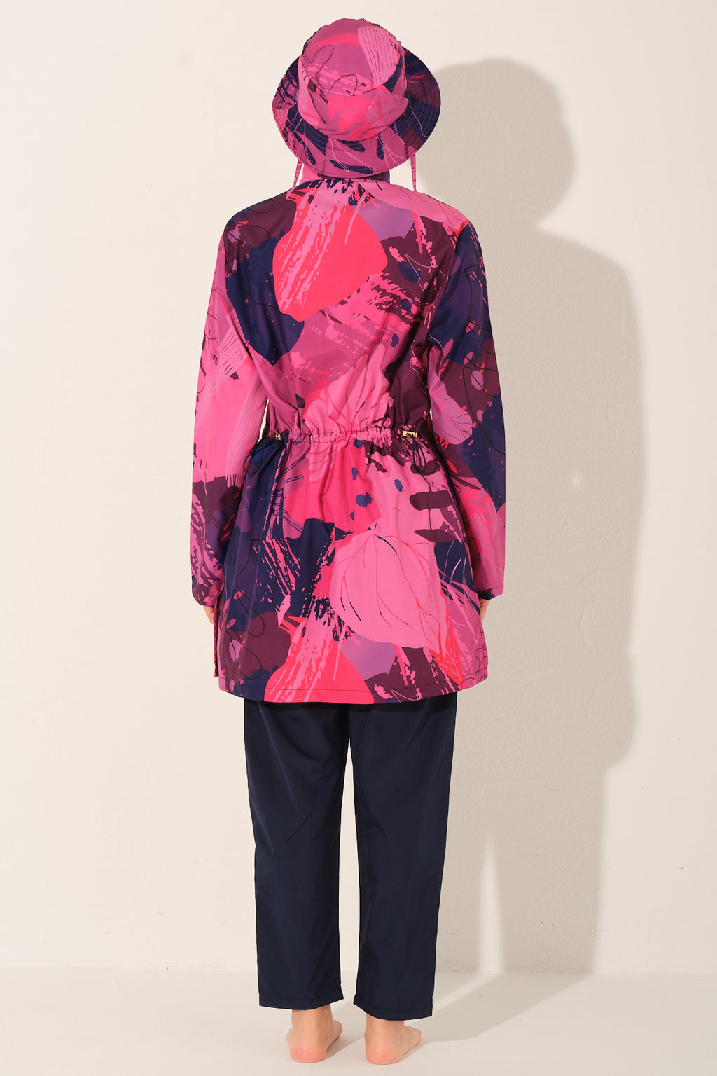 Model wearing pink Abstract print burkini set, back view, showing waist detail.