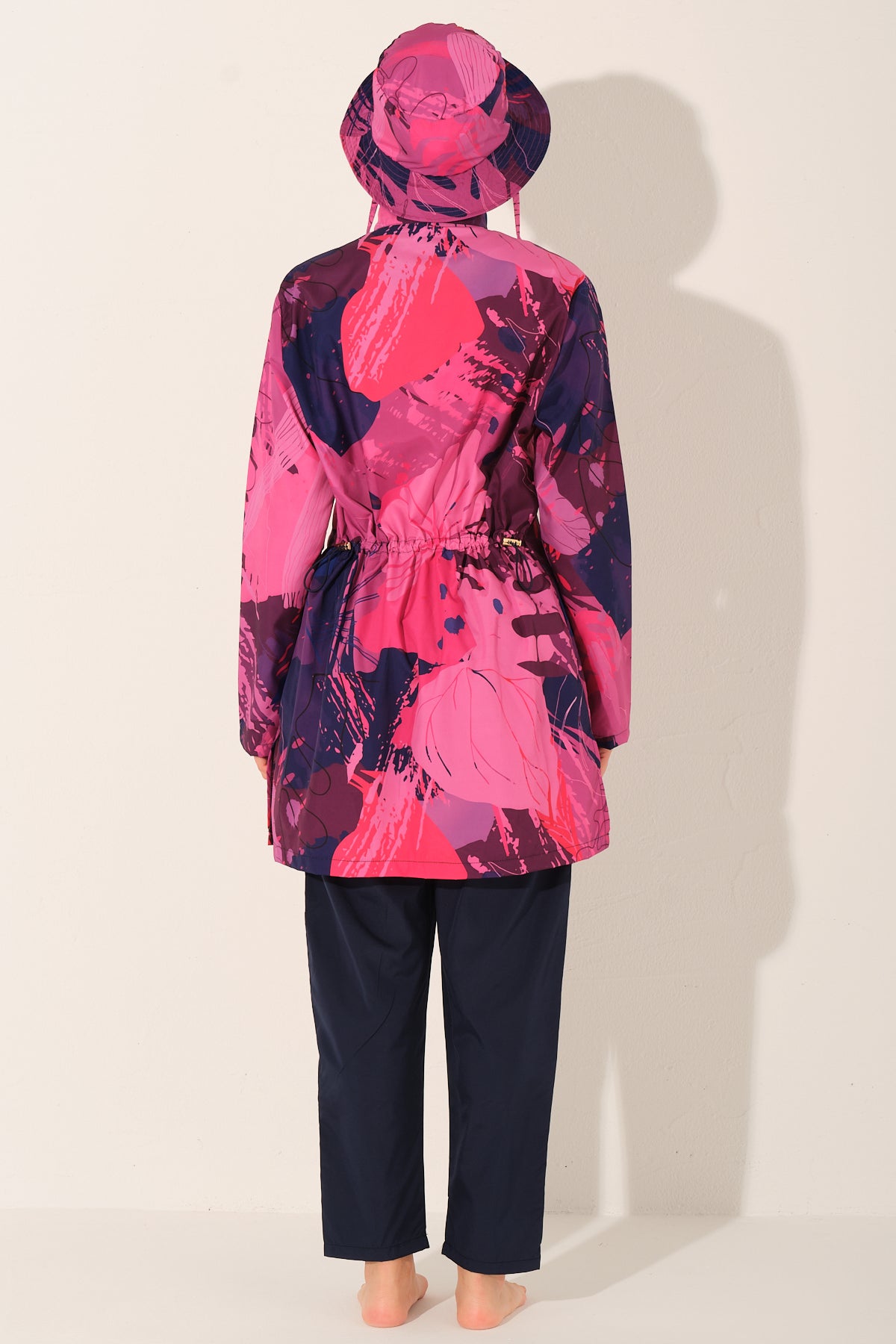 Model wearing pink Abstract print burkini set, back view, showing waist detail.