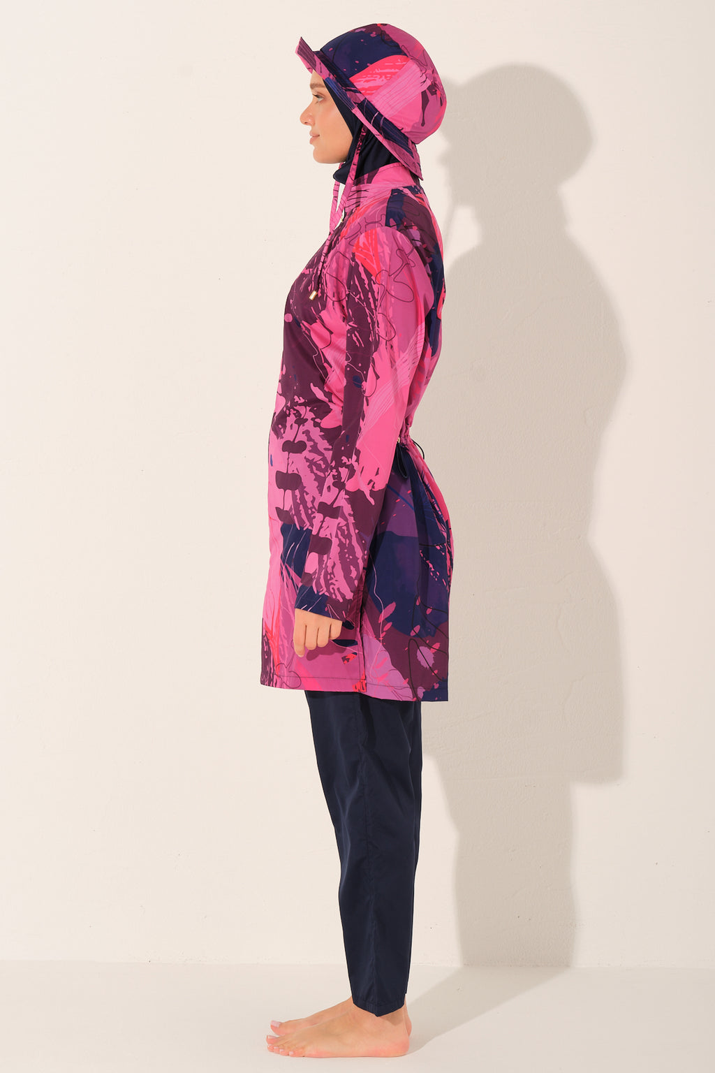 Model in navy Abstract  print burkini set, profile view, standing calmly.