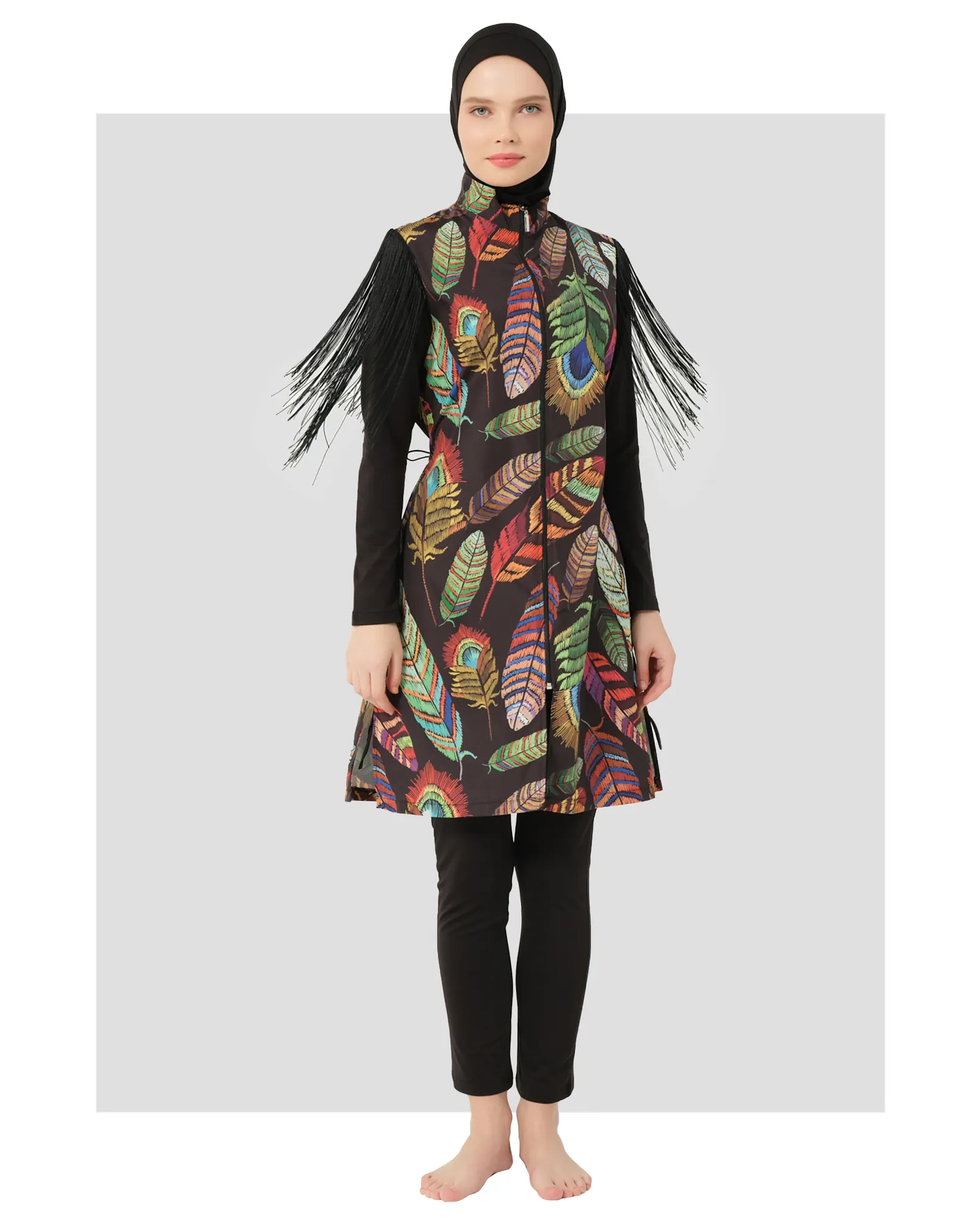 Model in bohemian feather-print burkini with fringe sleeves, front view.