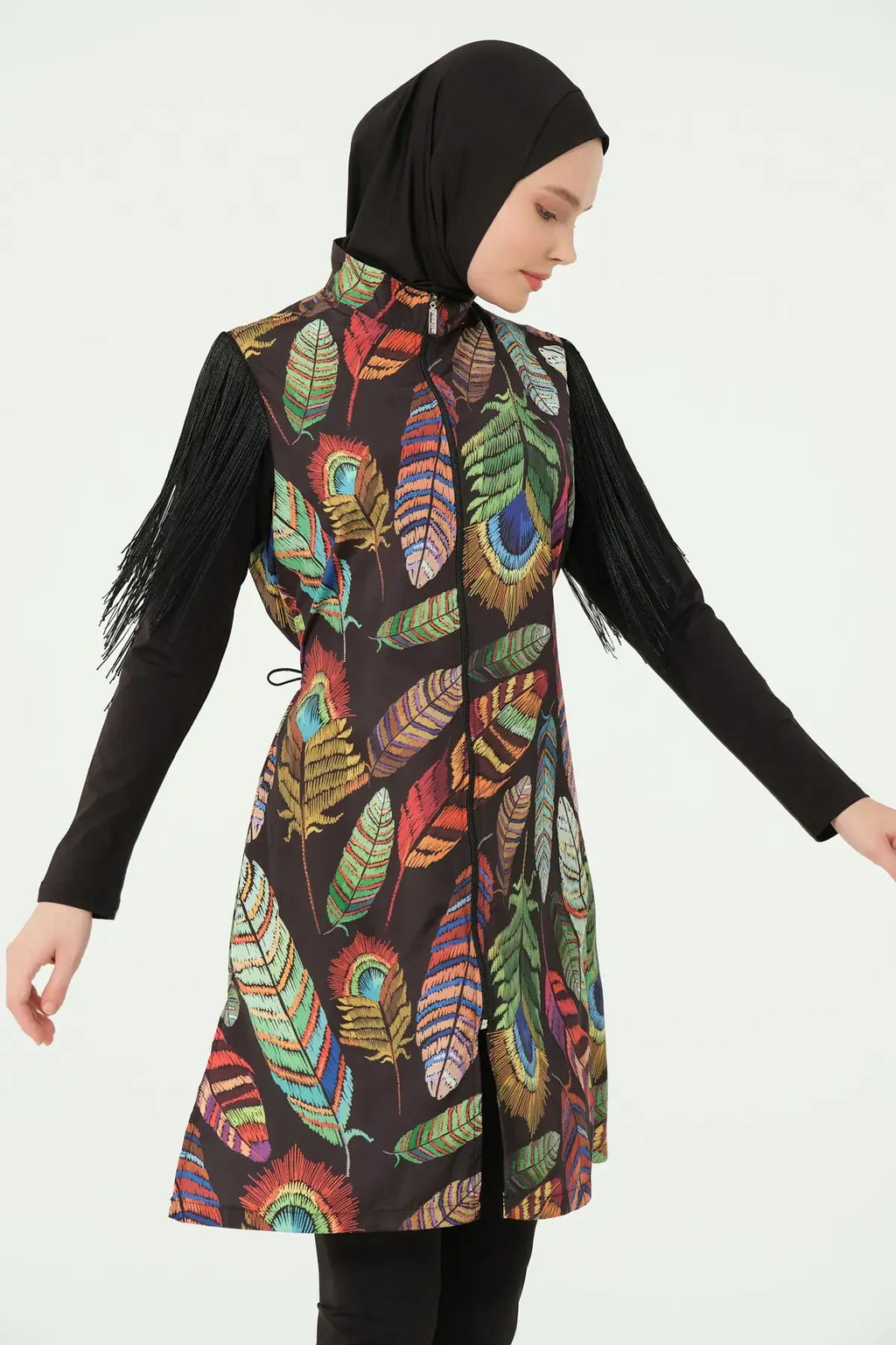 Model in bohemian feather-print burkini with fringe sleeves, slight side view.