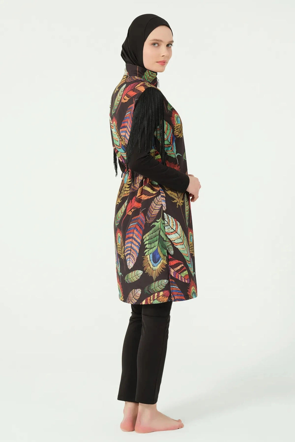 Model in bohemian feather-print burkini with fringe sleeves, side profile.