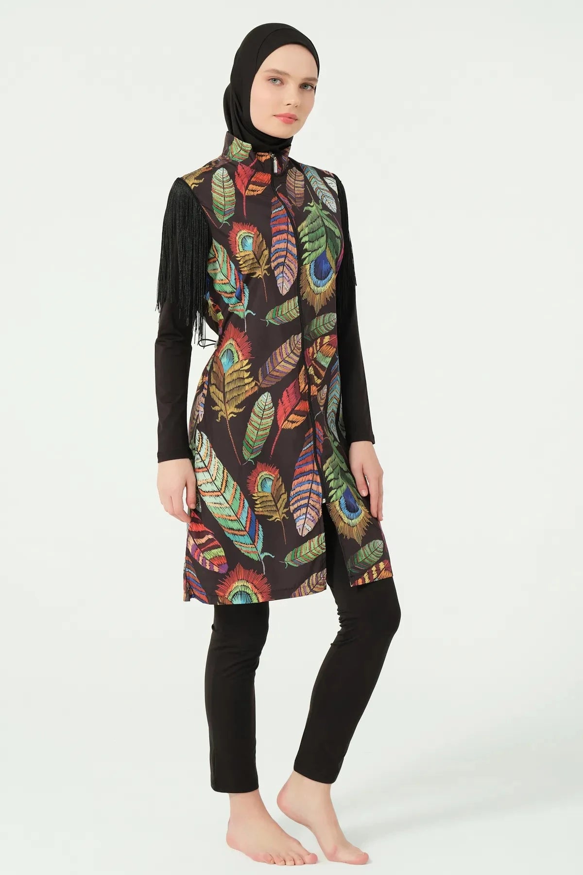 Model in bohemian feather-print burkini with fringe sleeves, full side view.