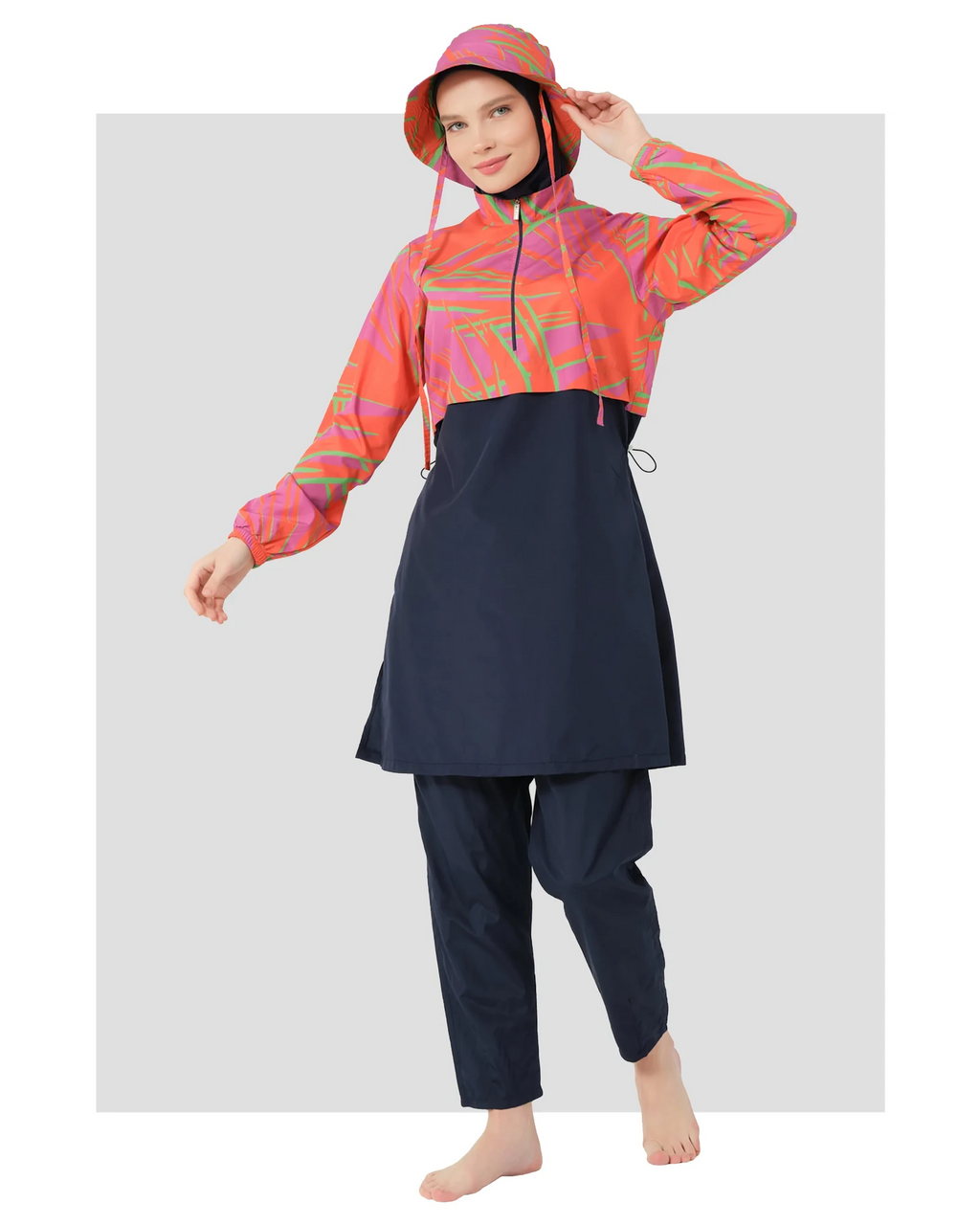 Woman in navy and orange burkini set with bucket hat, front view.