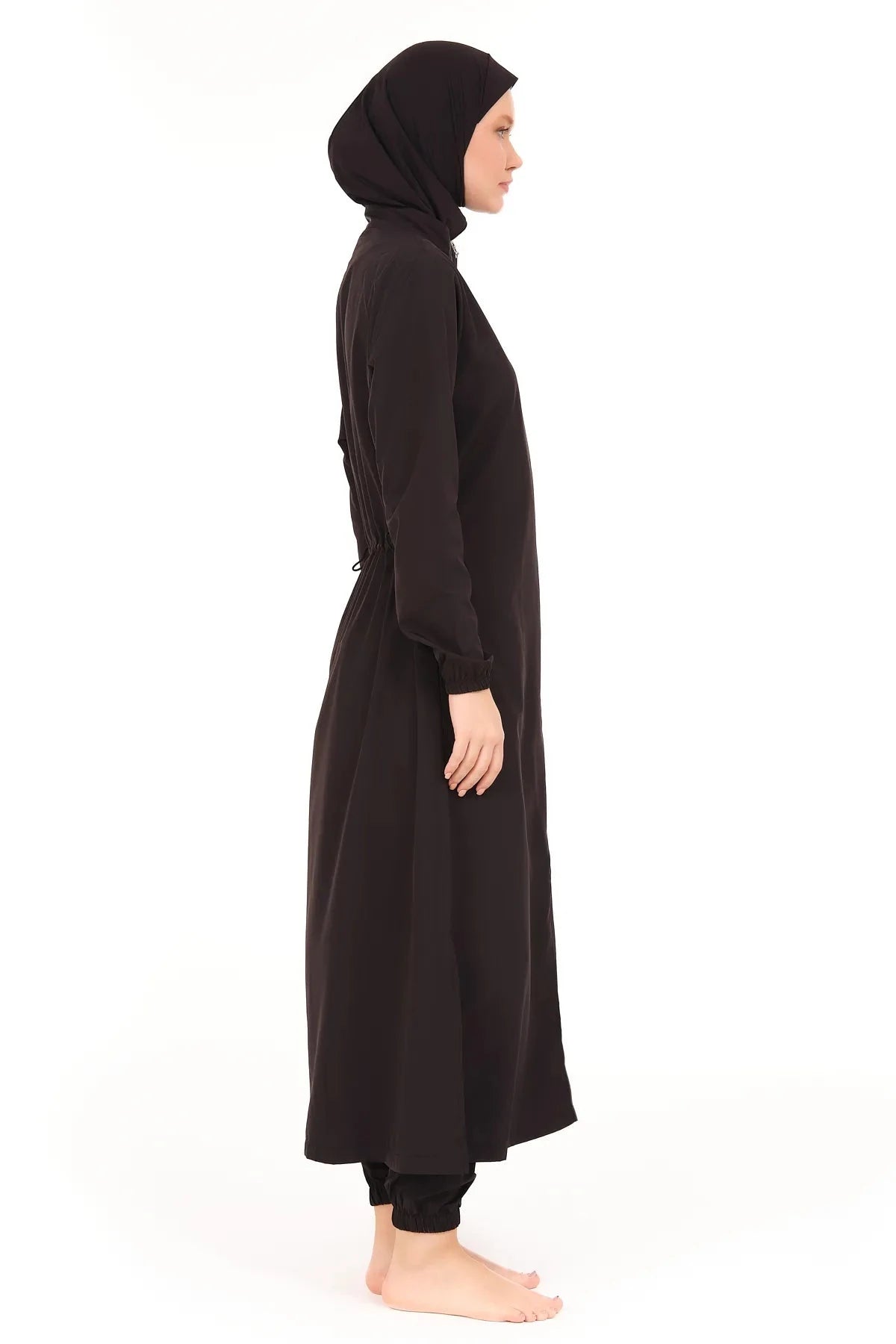 Side profile of woman in black modest burkini with full coverage.