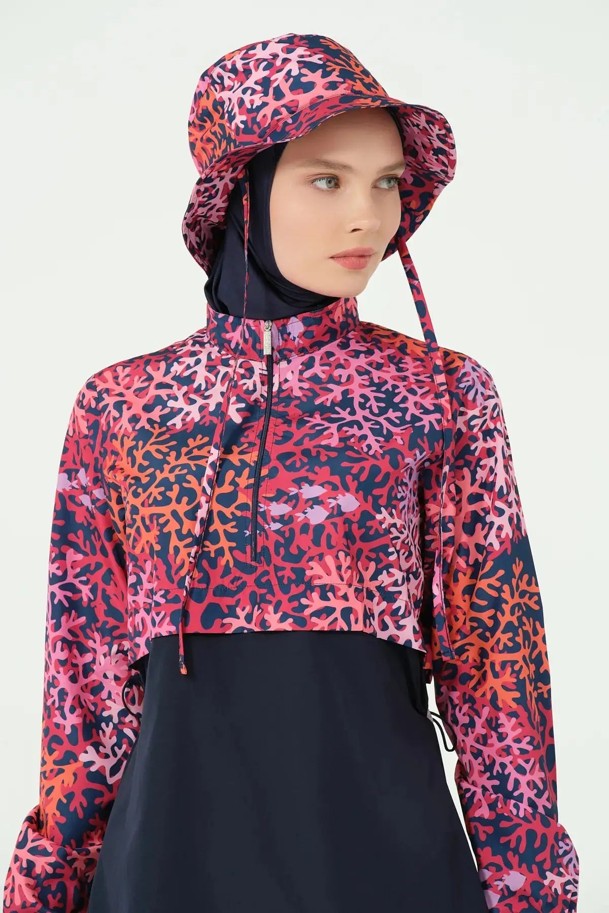 Close-up of coral print burkini jacket, hijab, and bucket hat.