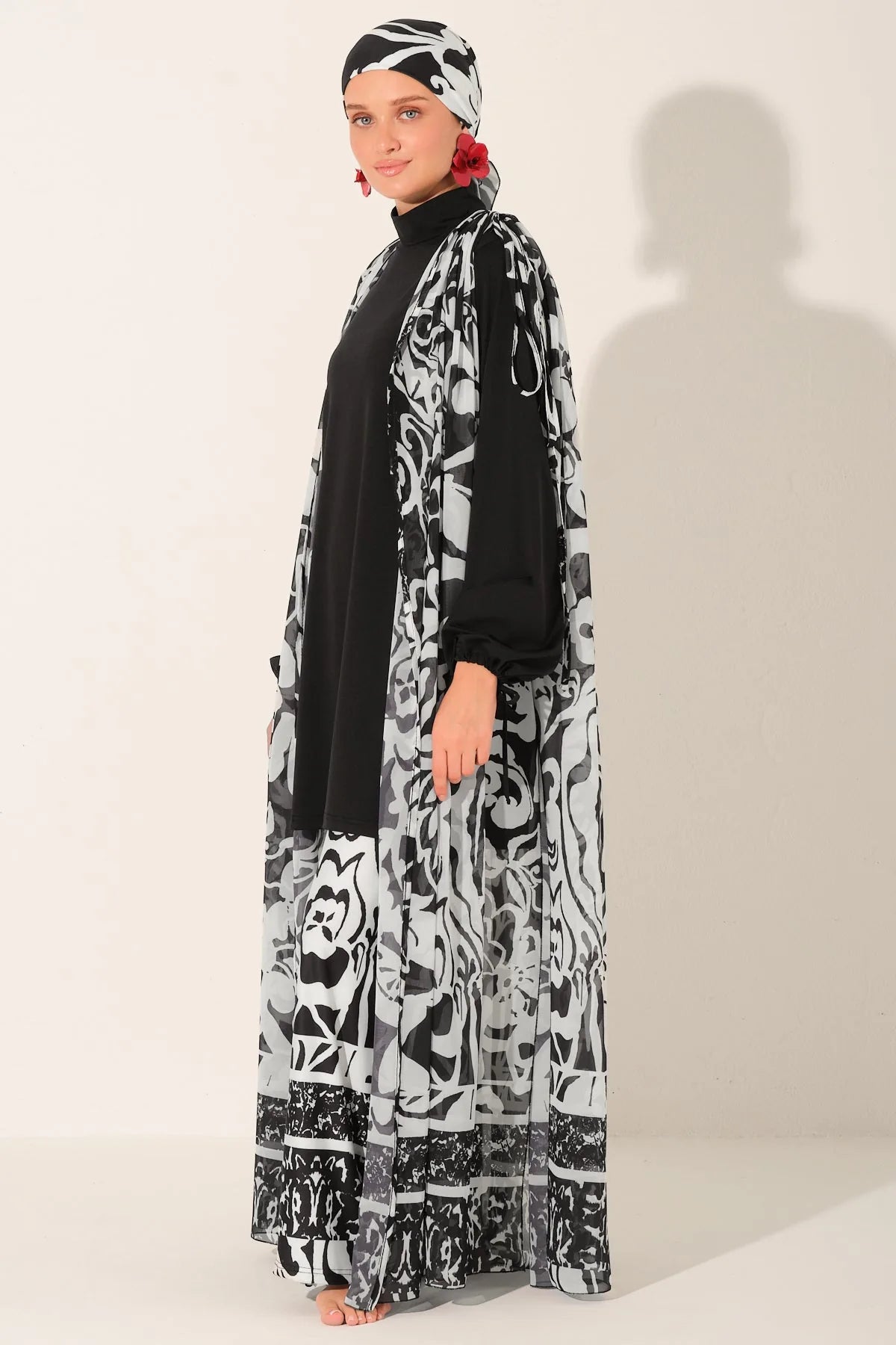 Side view of woman in black and white burkini with chiffon kimono.