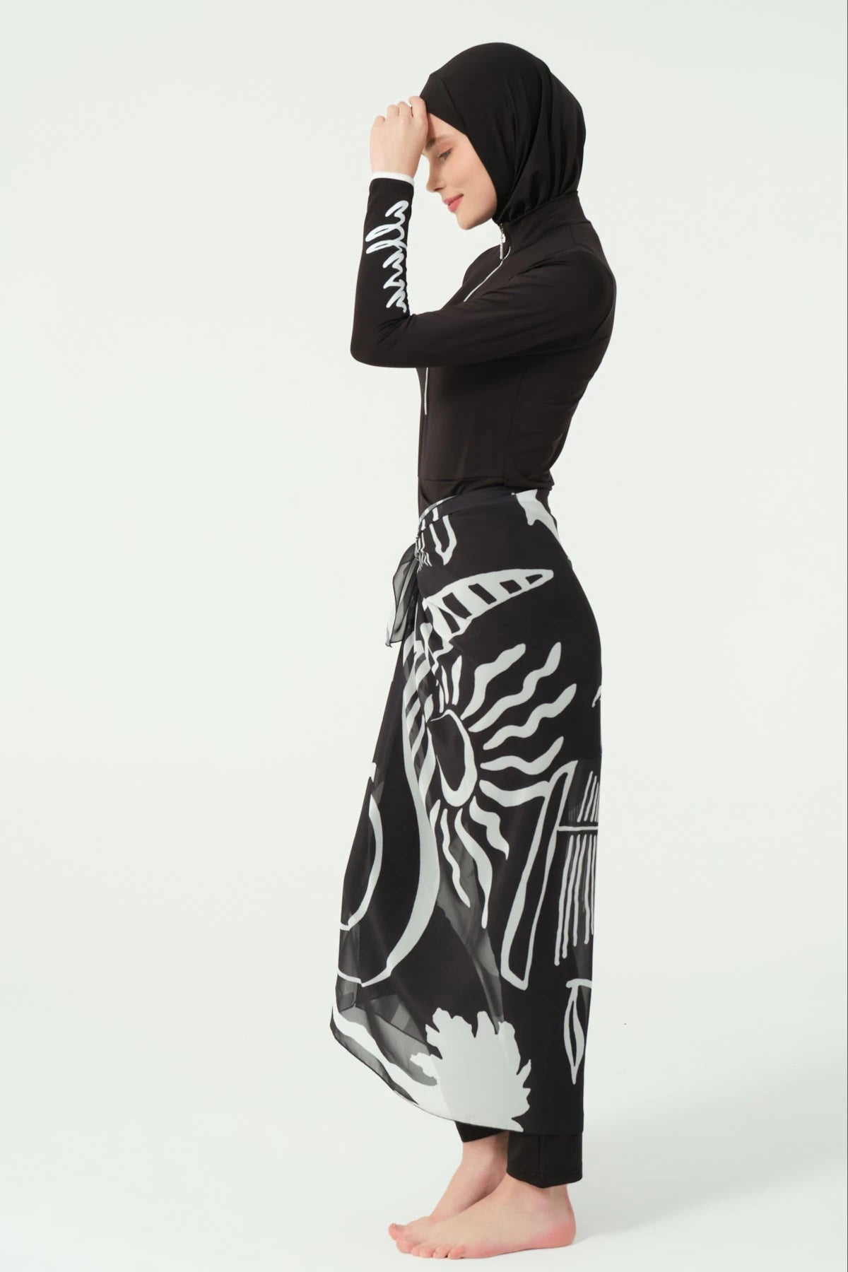 Black burkini set with printed sarong, side view on white background