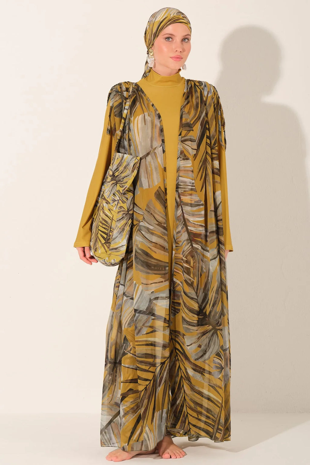 Woman in golden palm print burkini set with kimono closed.