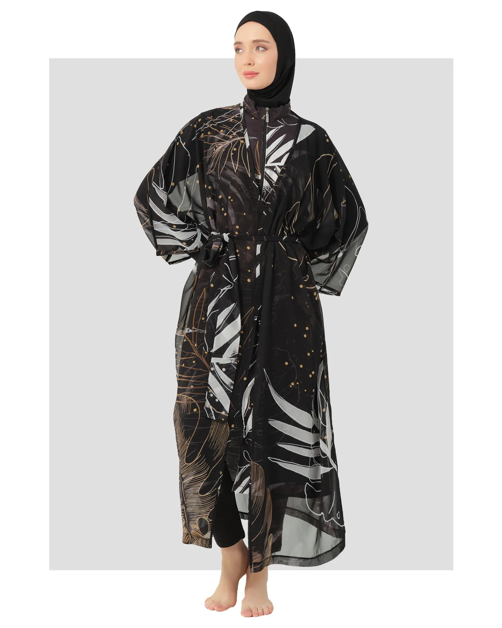 Model in black burkini with gold and white leaf print kimono.