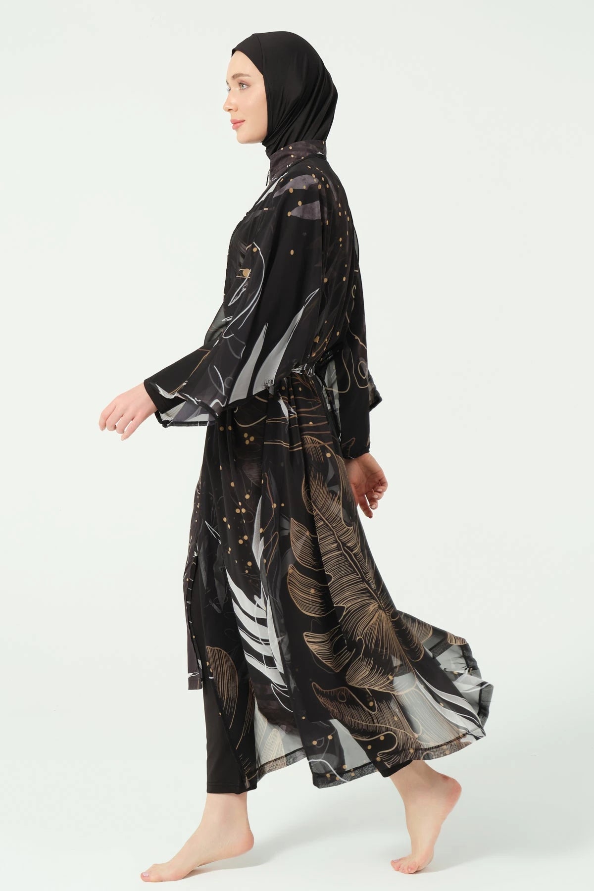 Model walking in black burkini with gold and white leaf print kimono.