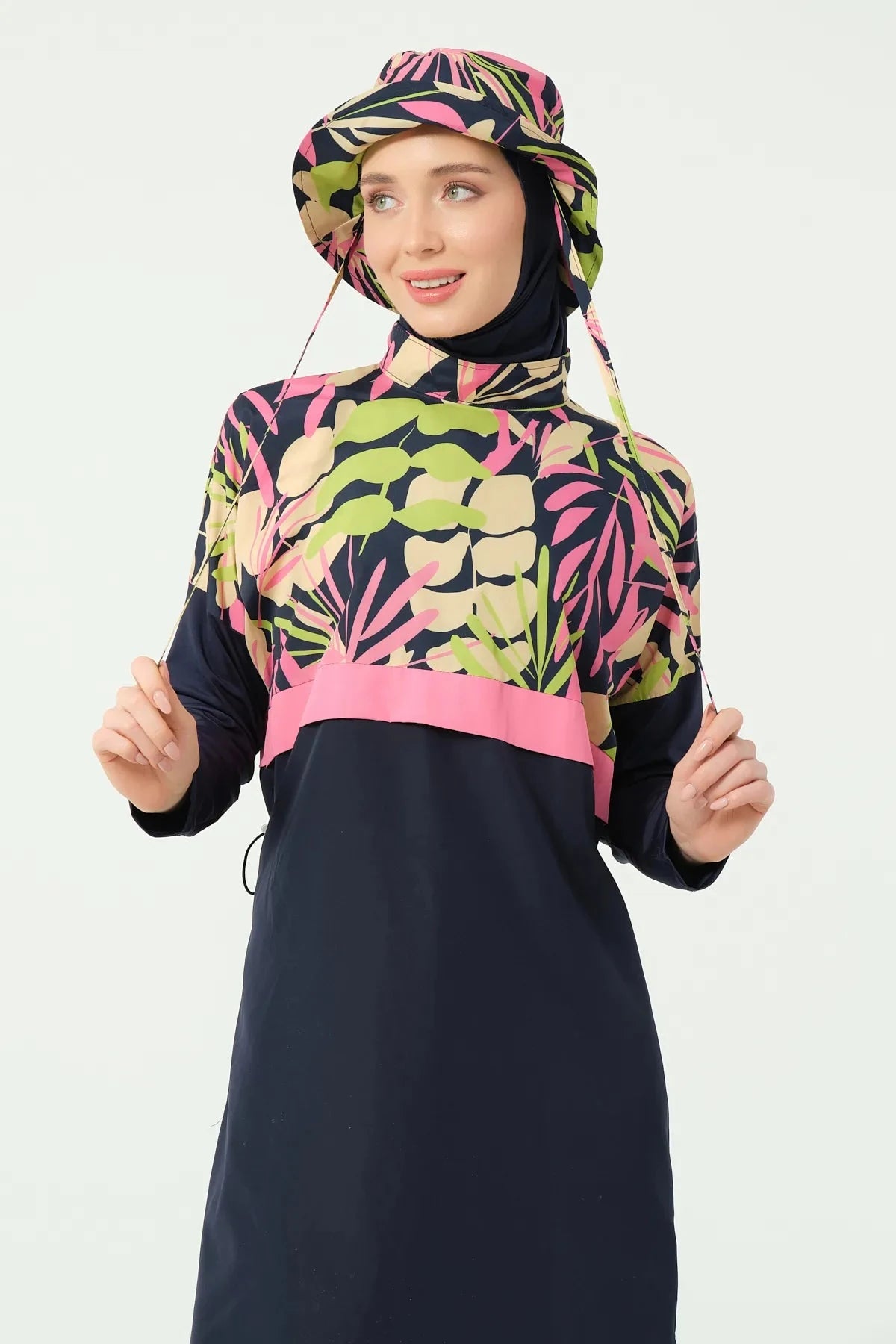 Woman wearing a colorful hijab and black dress with floral pattern on a white background