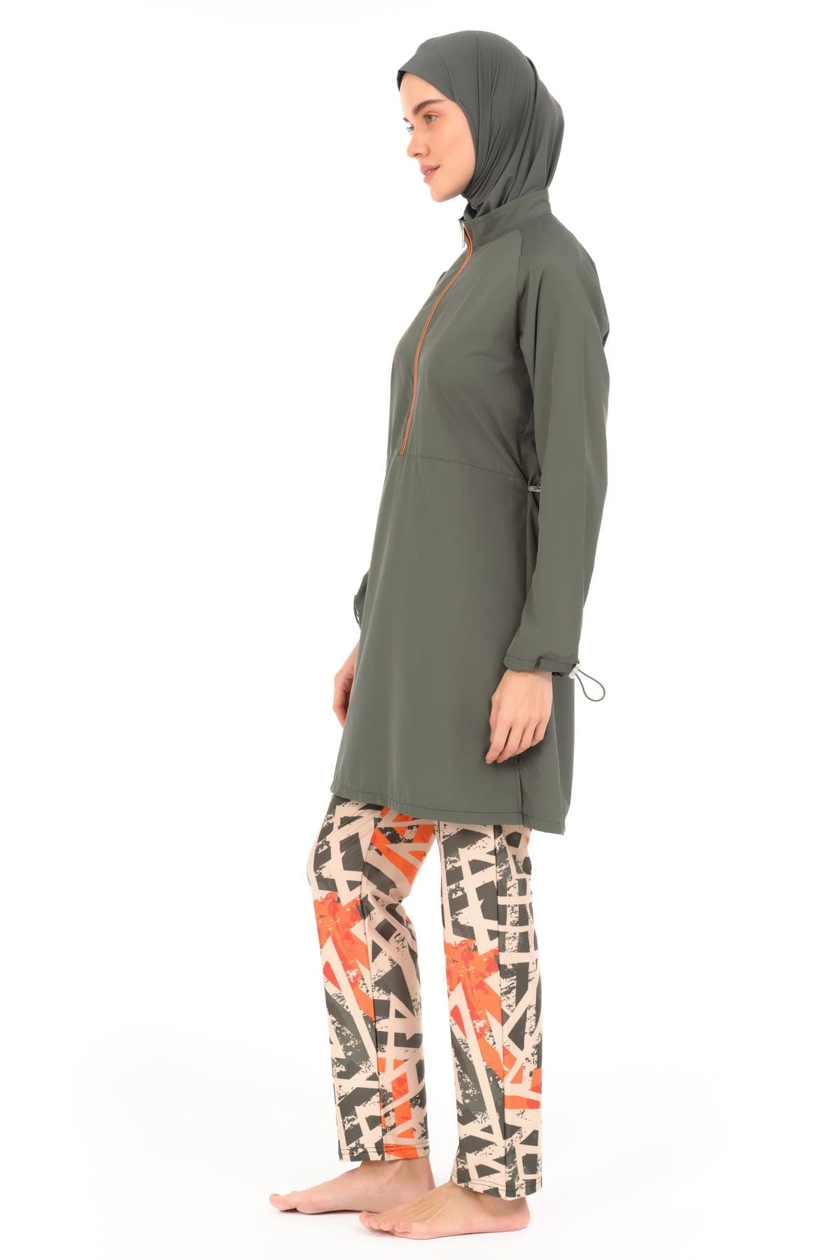 Woman in modern burkini with geometric print pants, side view.