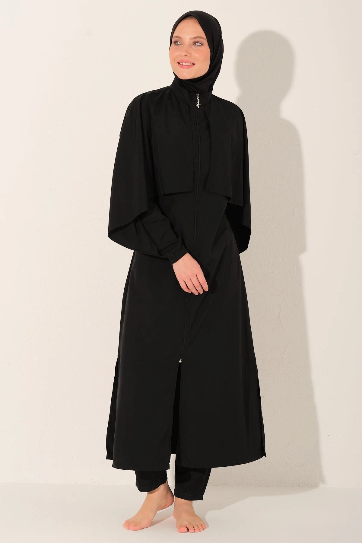 Black burkini set front view with model smiling.