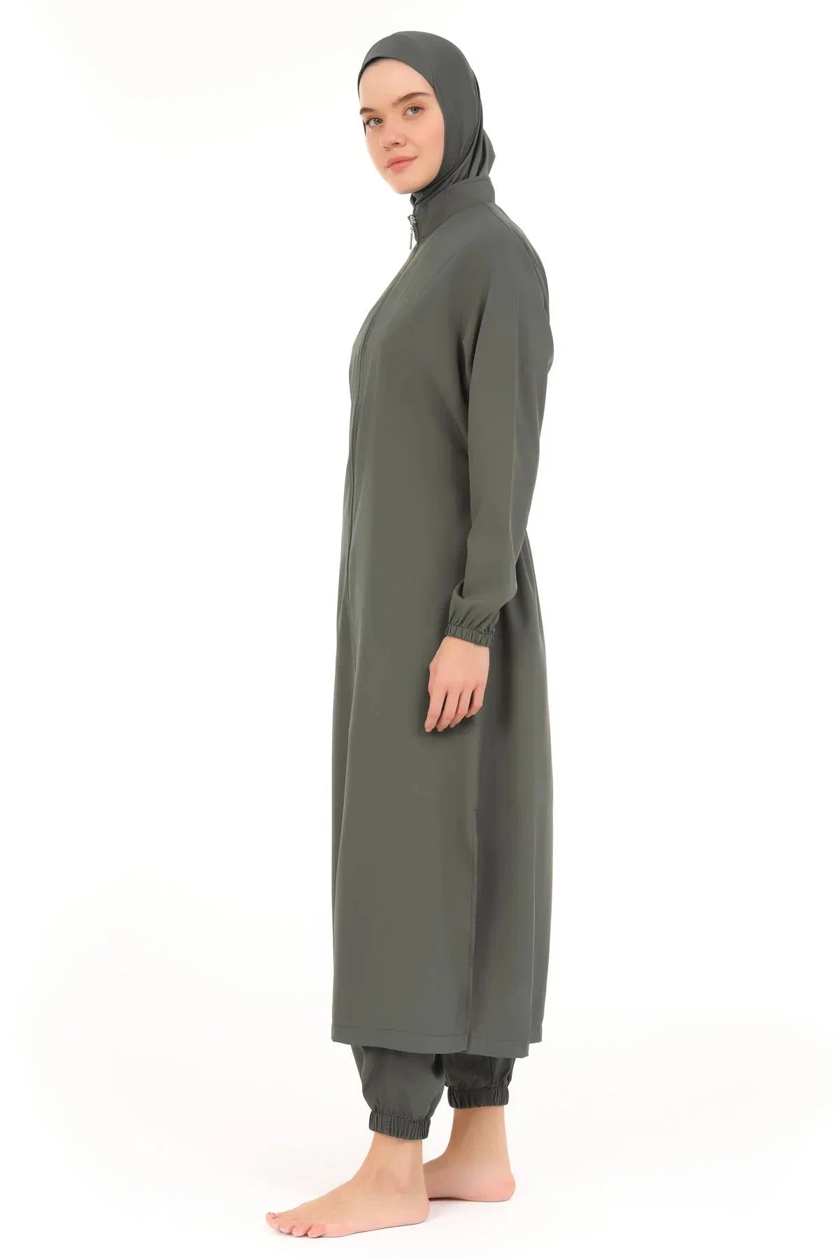 Model wearing olive green full-length burkini with elasticized ankle leggings side view.