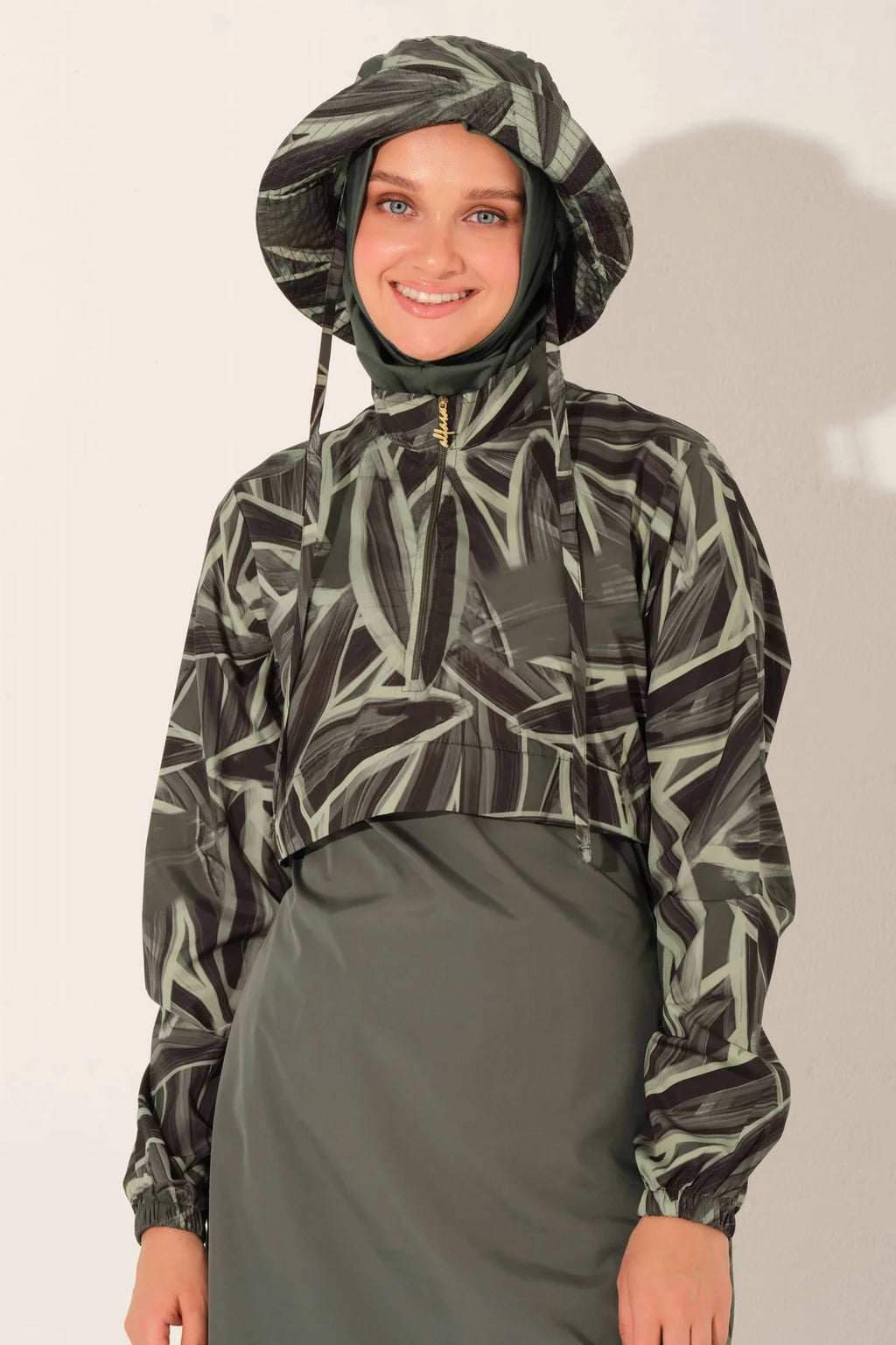 Close-up of woman wearing olive green patterned burkini top and hood.