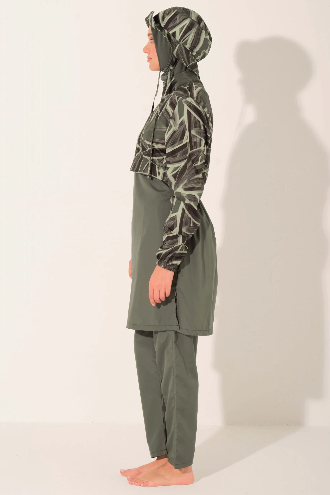 Side view of olive green burkini with patterned top and full coverage.