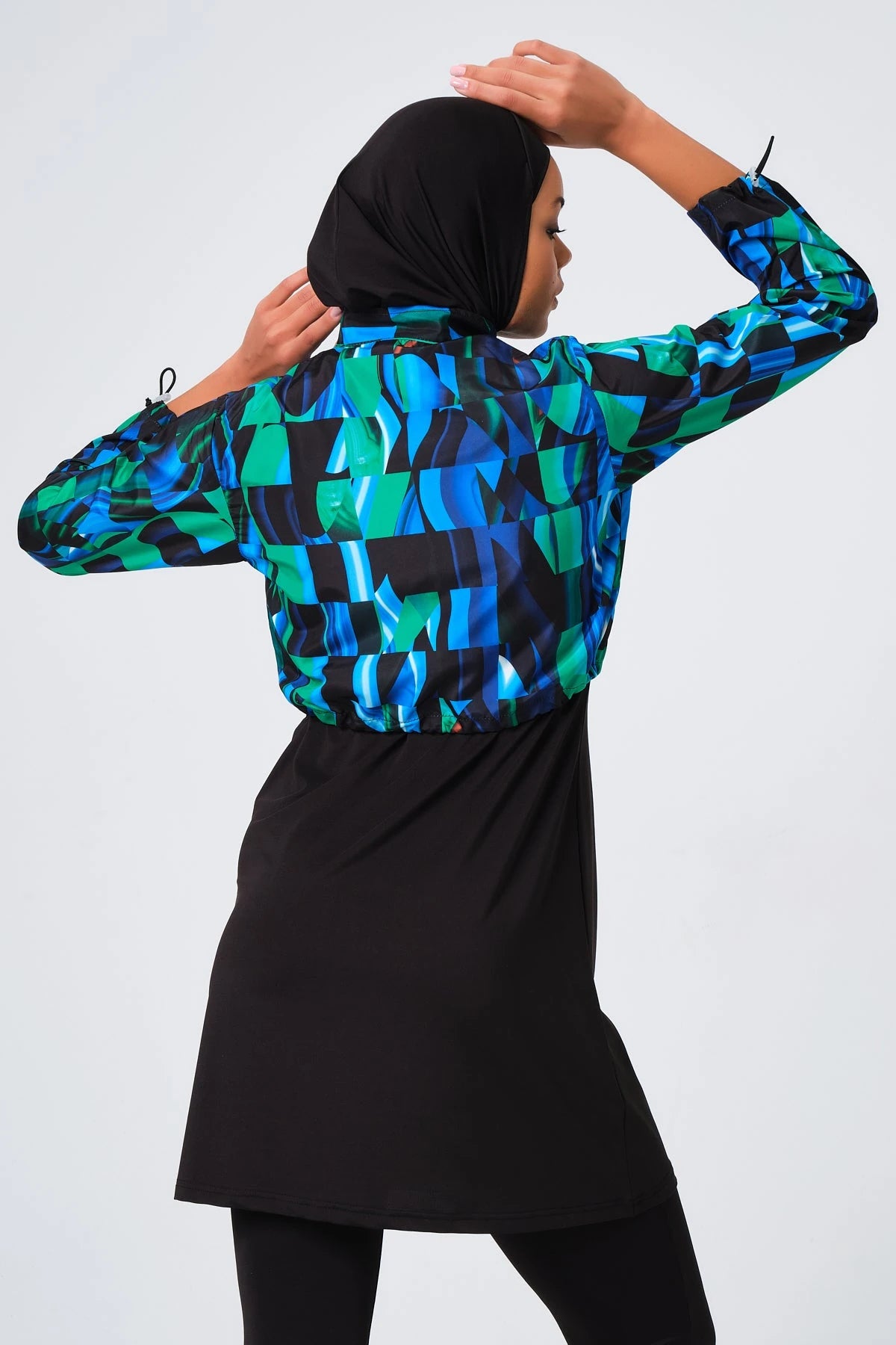 Sporty burkini with blue green abstract print jacket upper body detail.