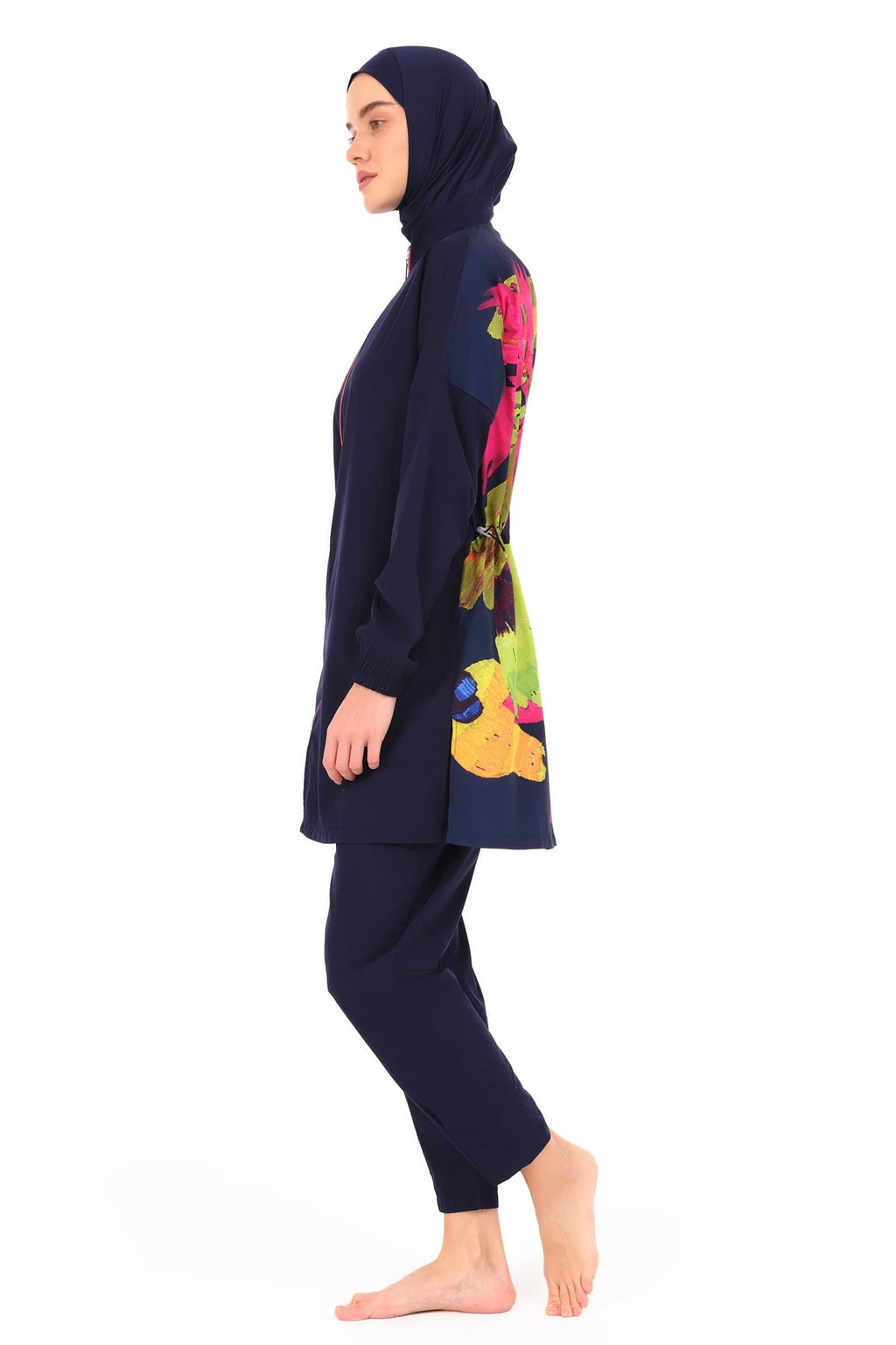 Navy burkini with vibrant floral design on side, model in profile.