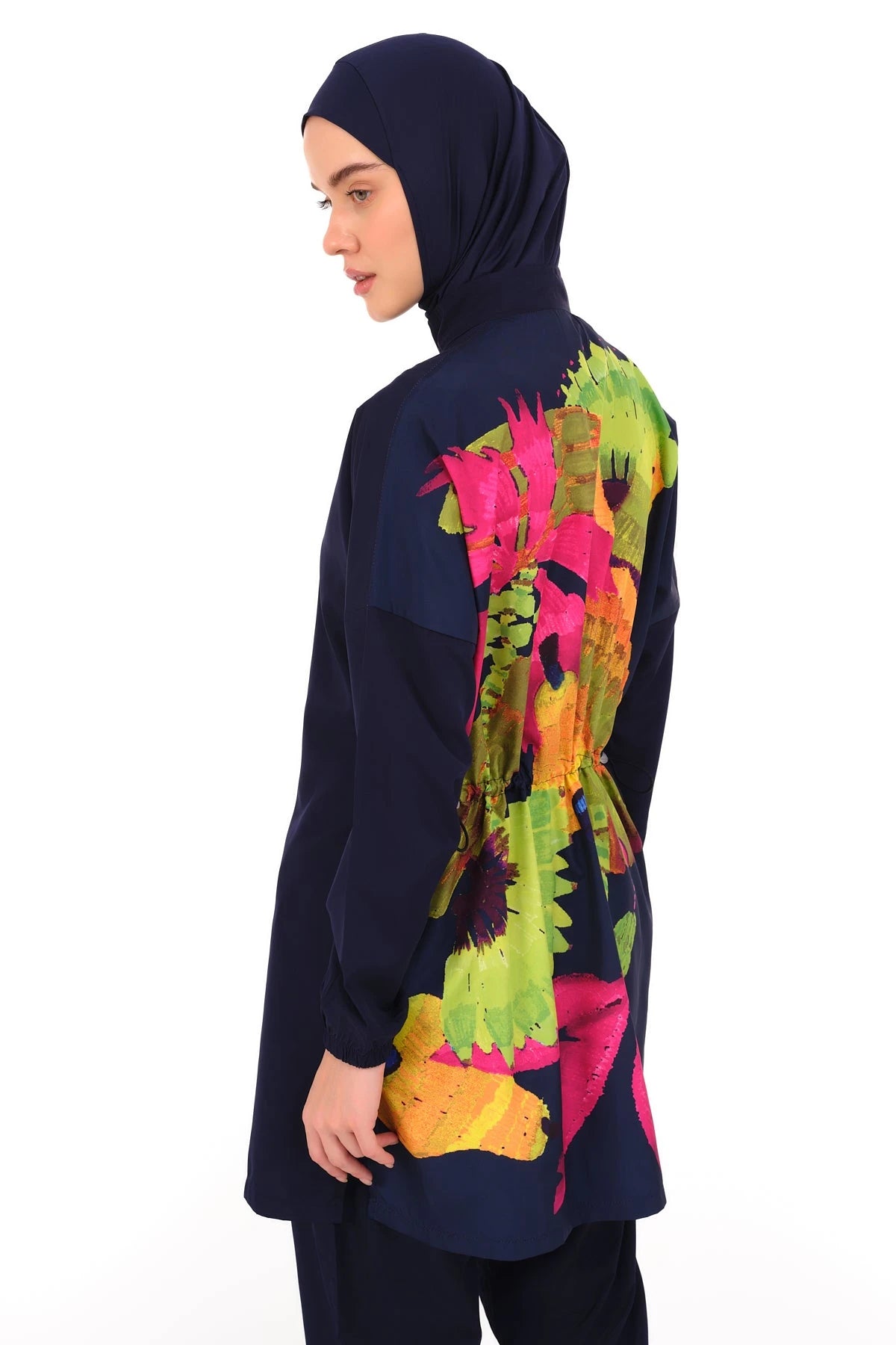 Navy burkini with vibrant floral back design, model looking left.