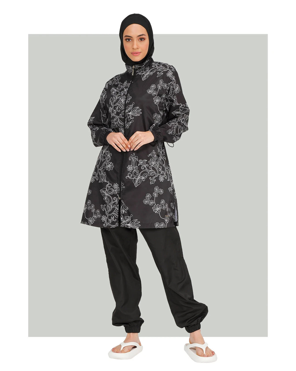Black burkini set with white floral embroidery, front view.