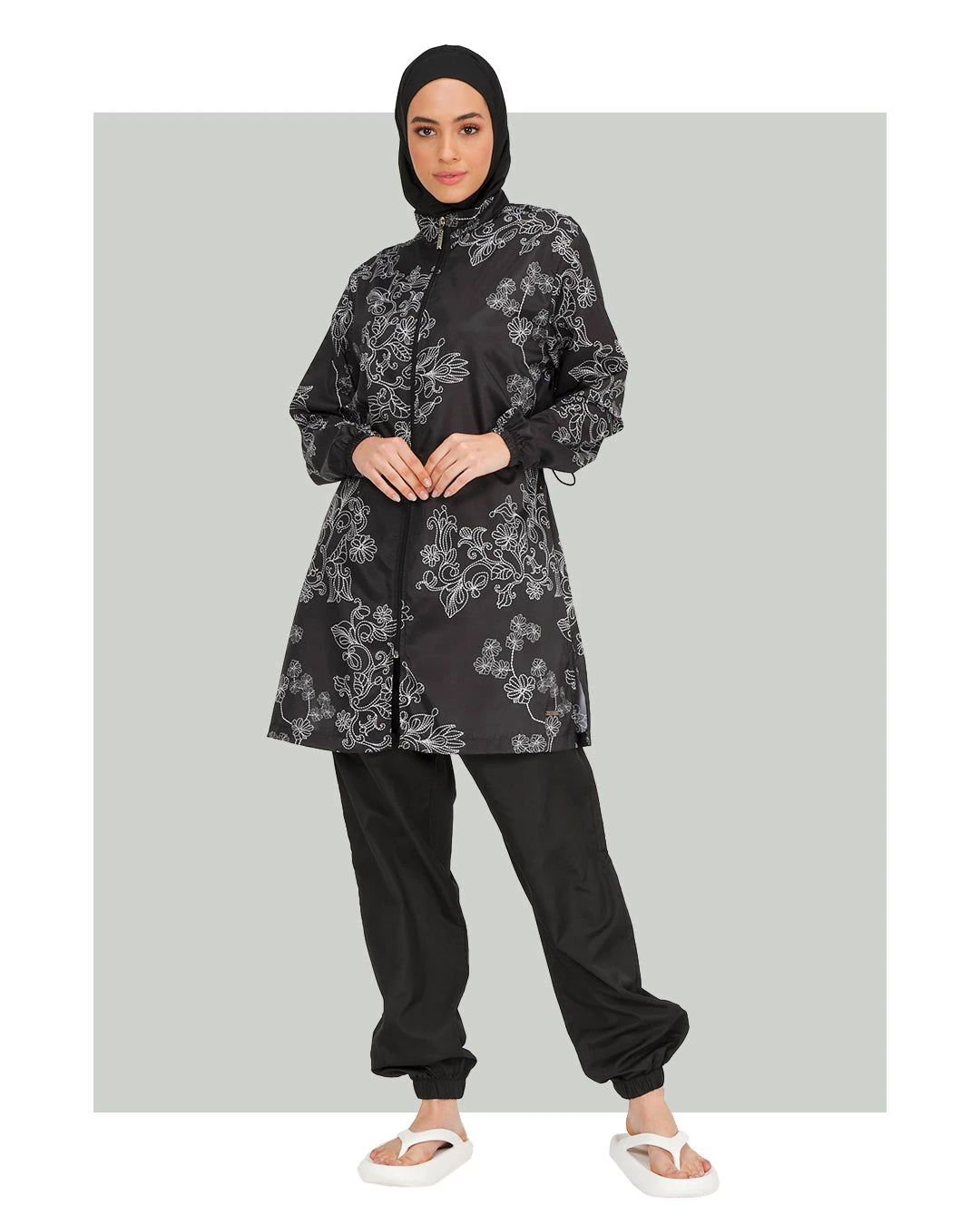 Black burkini set with white floral embroidery, front view.