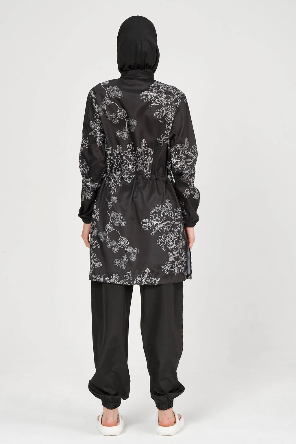 Black burkini set with white floral embroidery, back view.