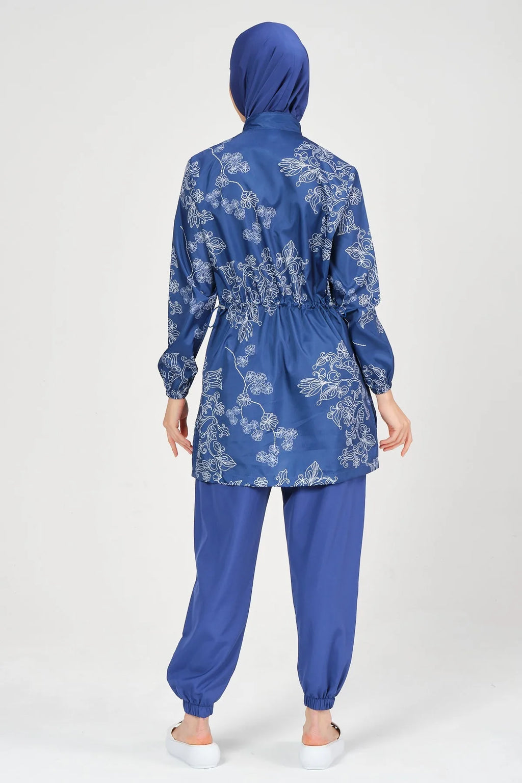 Blue burkini set with floral embroidery, back view, on white background.