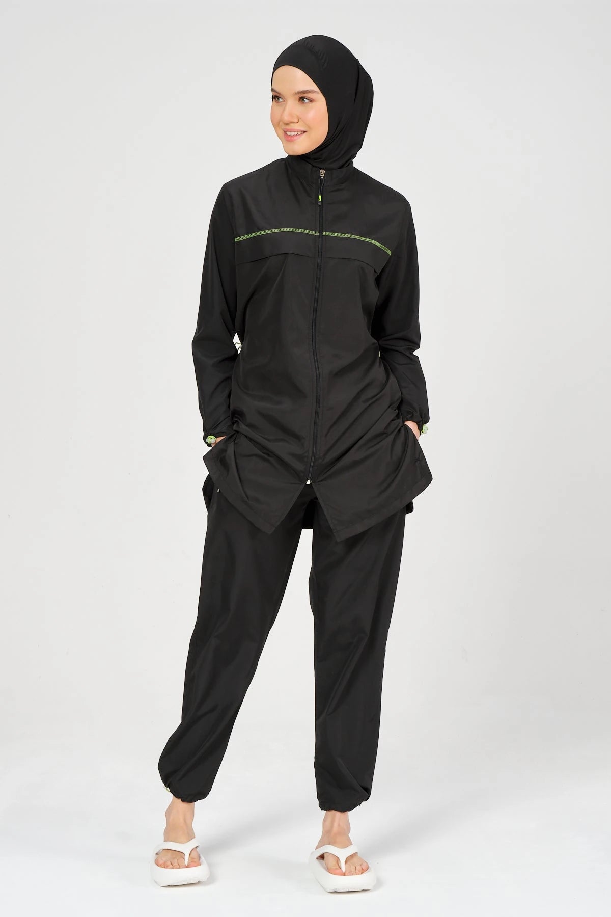 Full body view of black burkini set with neon accents and hijab.