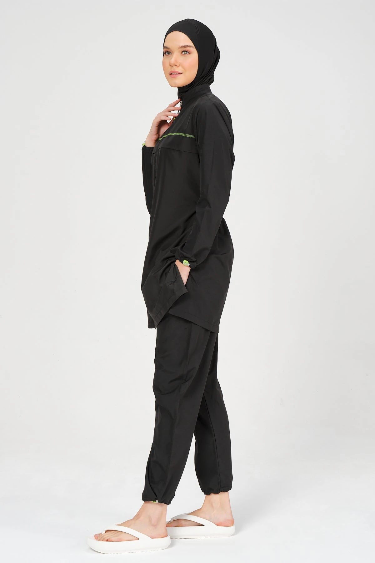 Side view of black burkini set with neon accents and jogger pants.