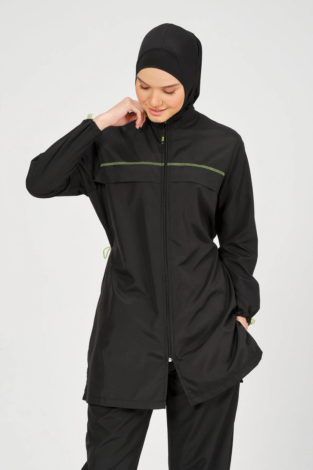 Close-up of black burkini top with neon piping and zipper detail.