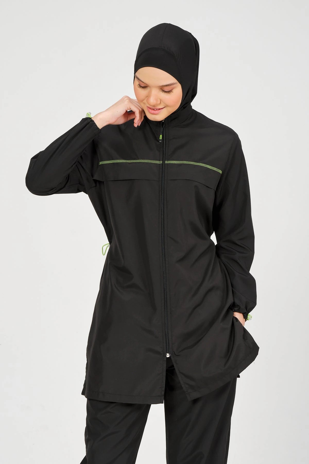 Close-up of black burkini top with neon piping and zipper detail.