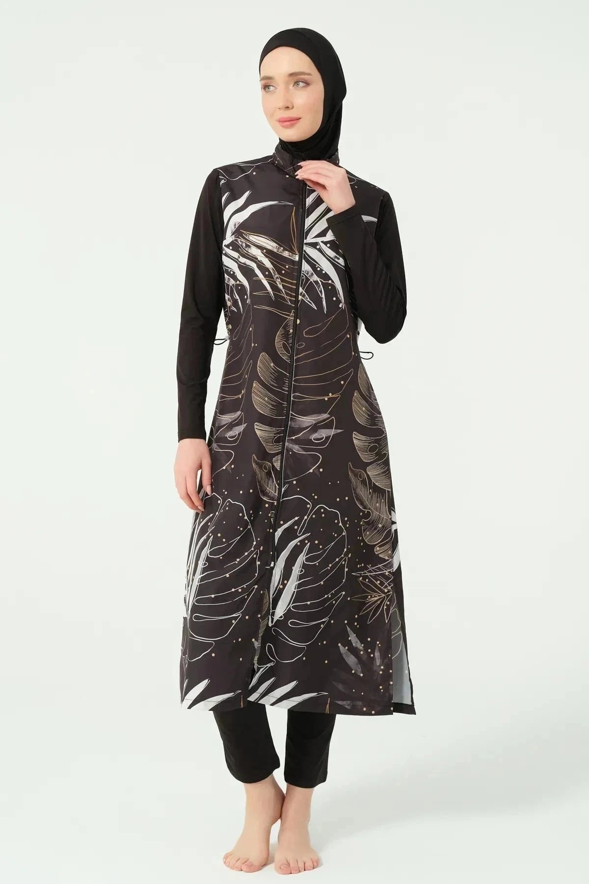 Close-up of black burkini with gold and white leaf print, front zipper.