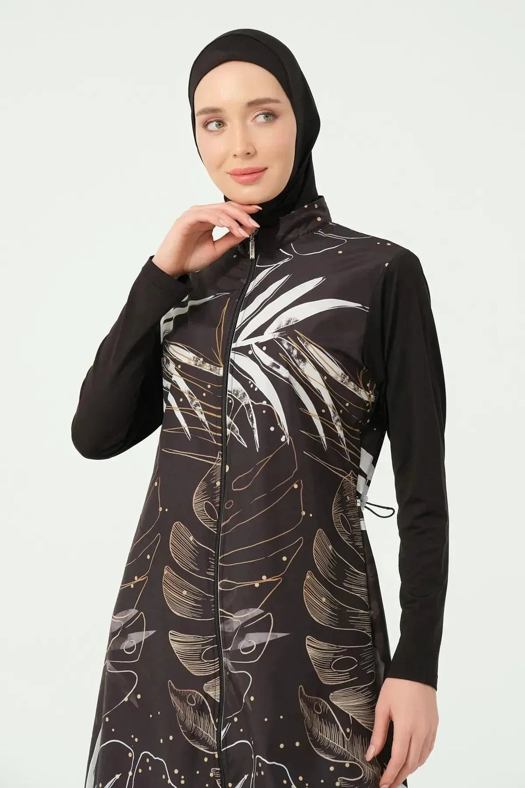Close-up of woman wearing black burkini with leaf print, face detail.