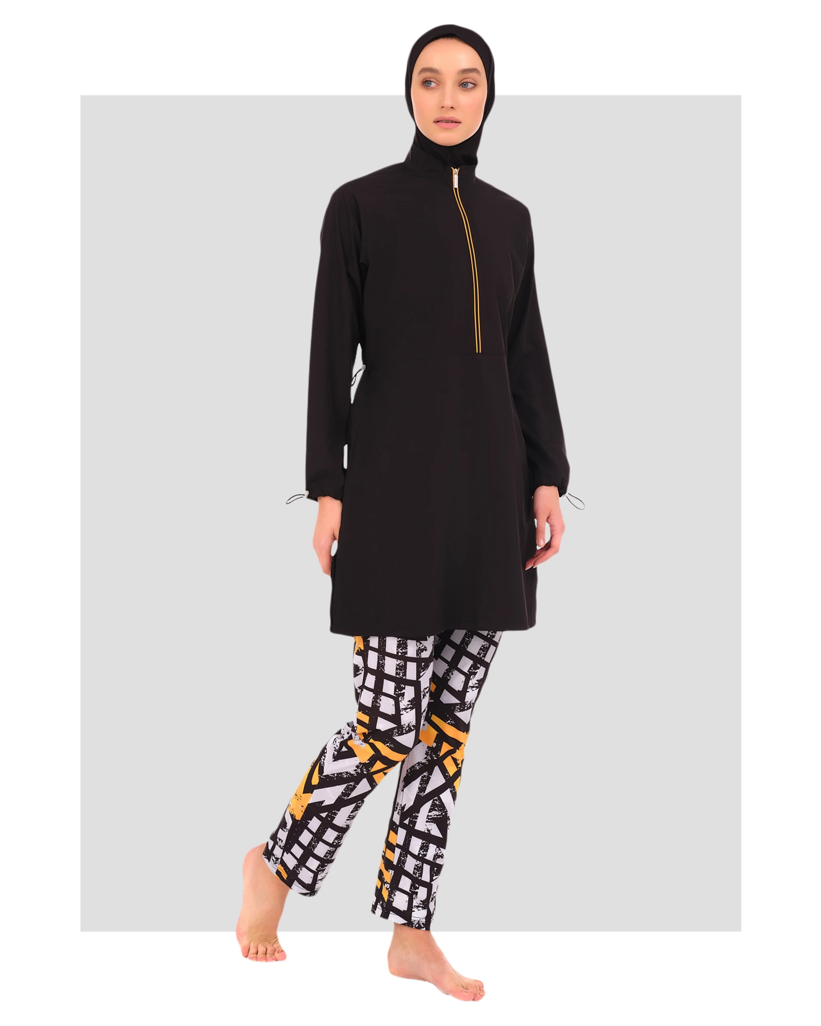 Woman in black burkini top and geometric print swim pants.