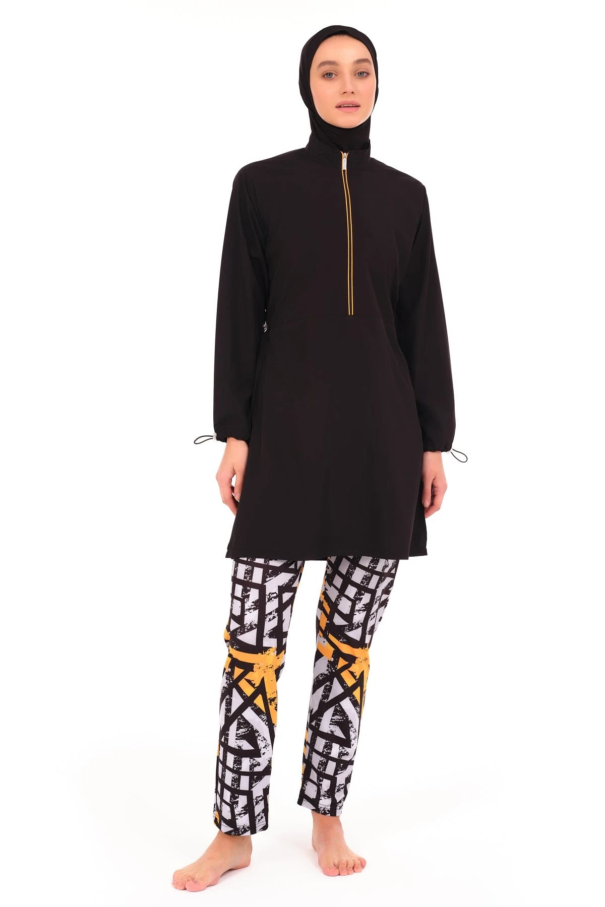 Full view of black burkini with geometric print pants on model.