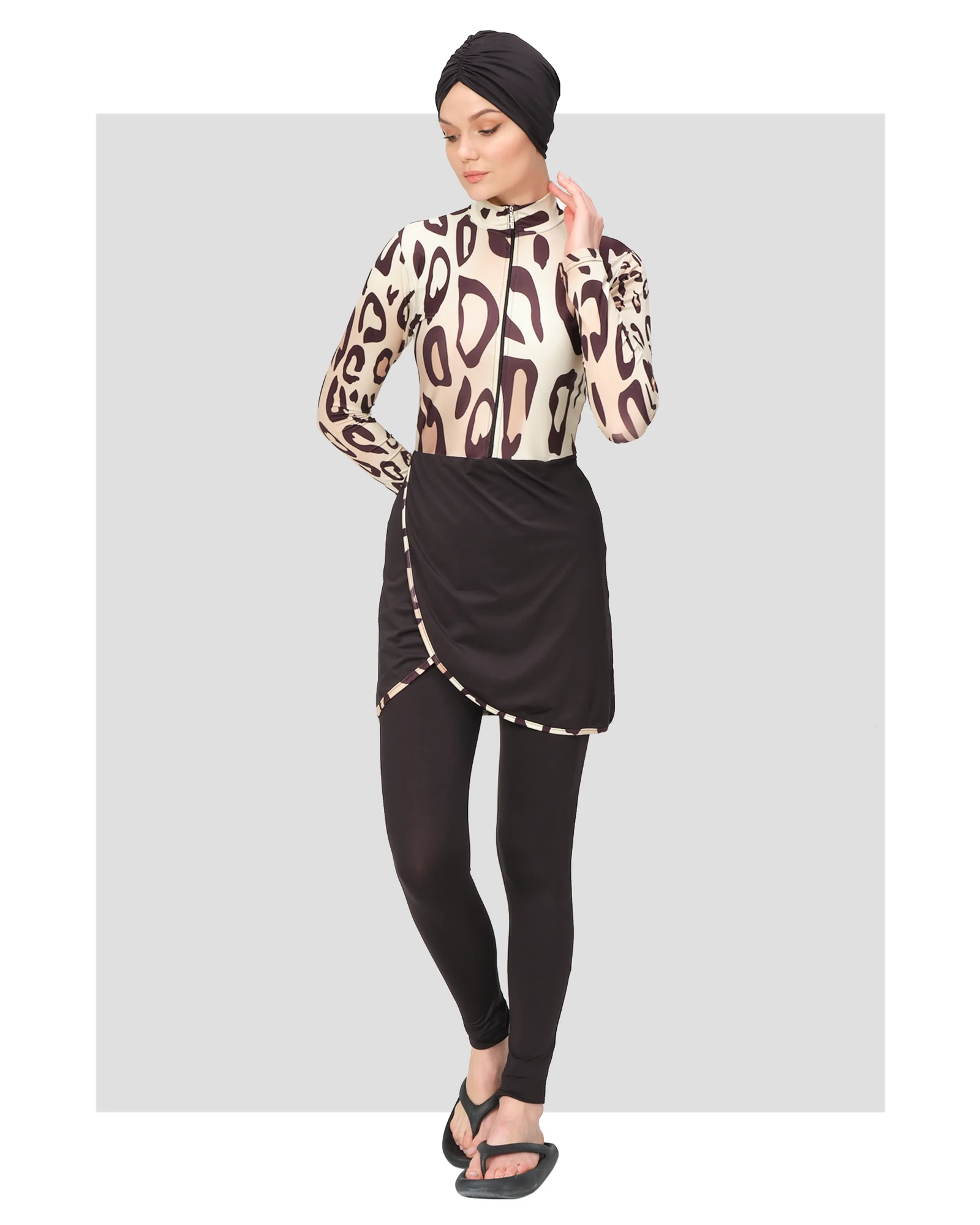 Woman wearing leopard print burkini swimsuit with black turban, front view.