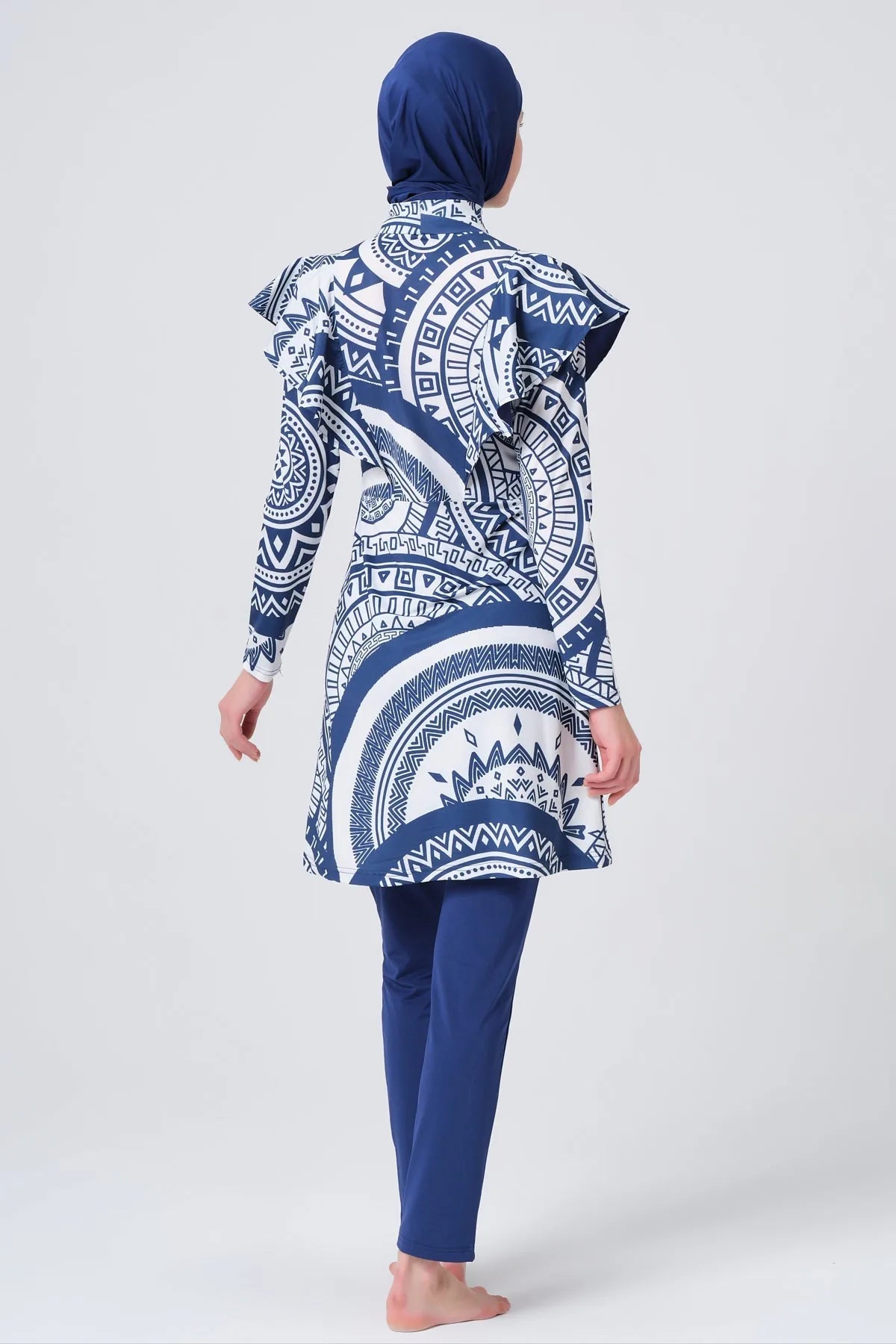 Model in blue and white geometric print burkini back view.