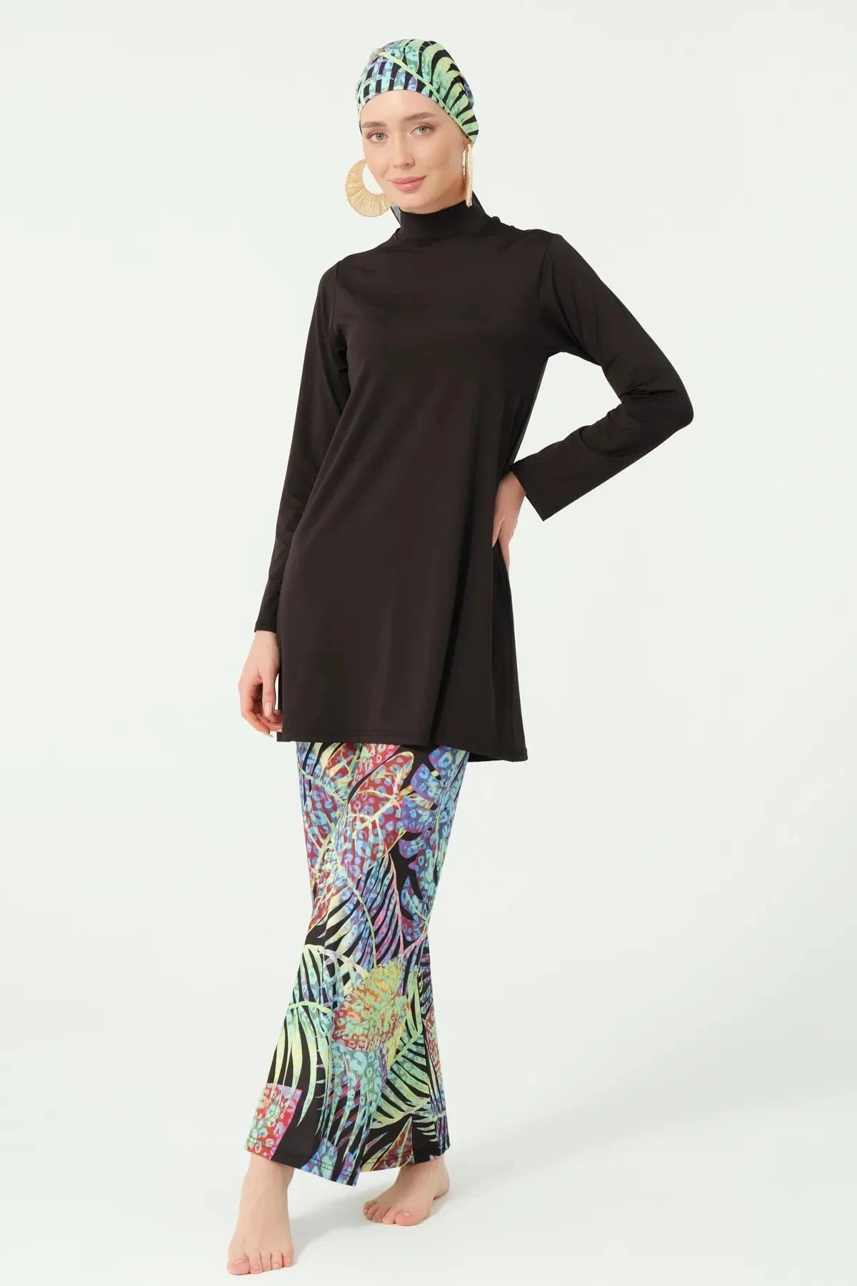 Front angled view of black burkini with tropical leaf print pants.