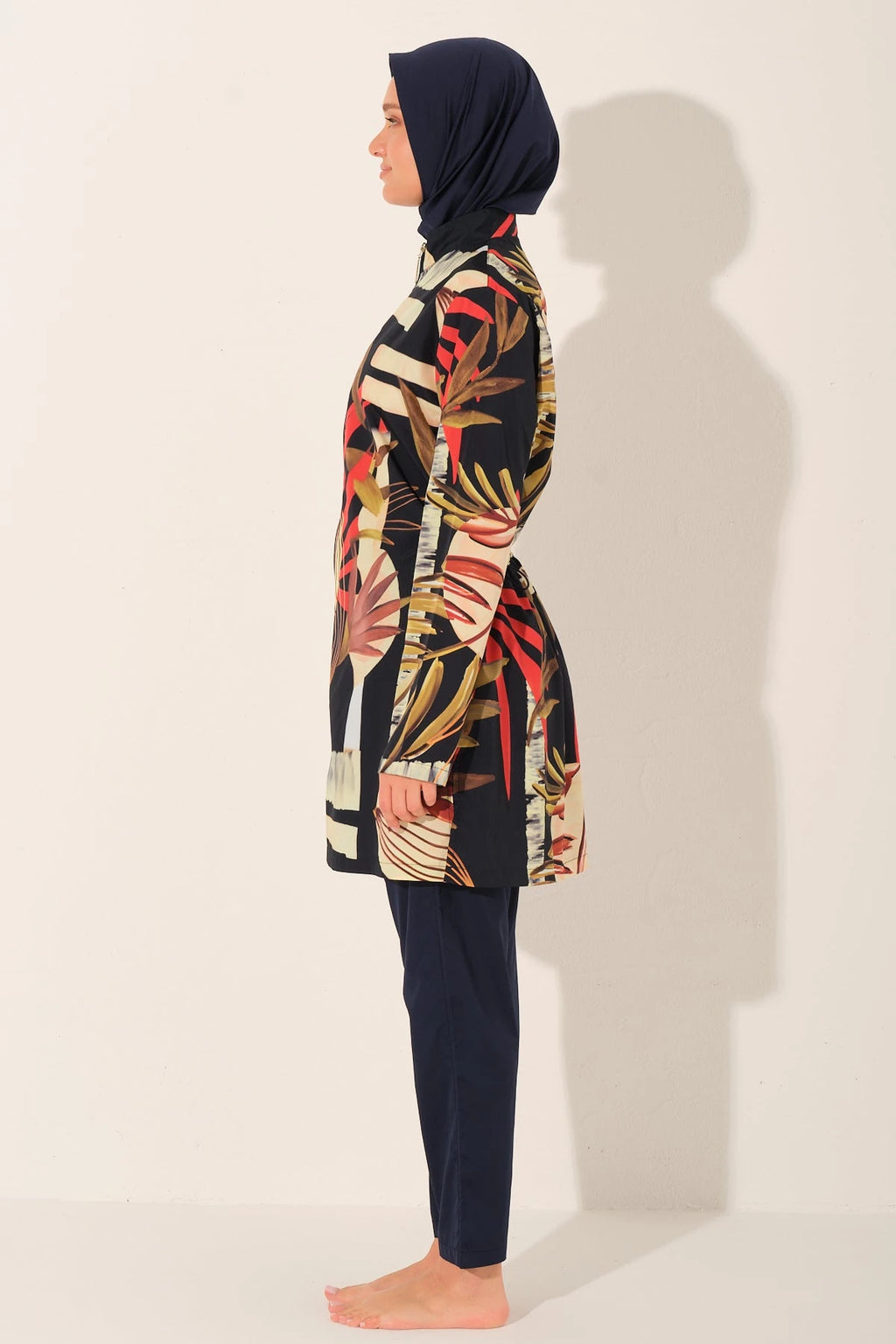 Side view of model wearing tropical print burkini set with hijab.