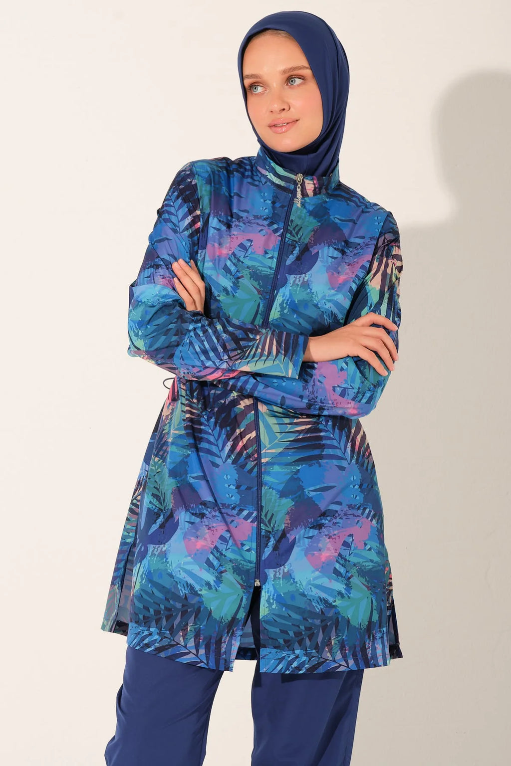 Model in blue tropical burkini set, arms crossed, showing drawstring waist.