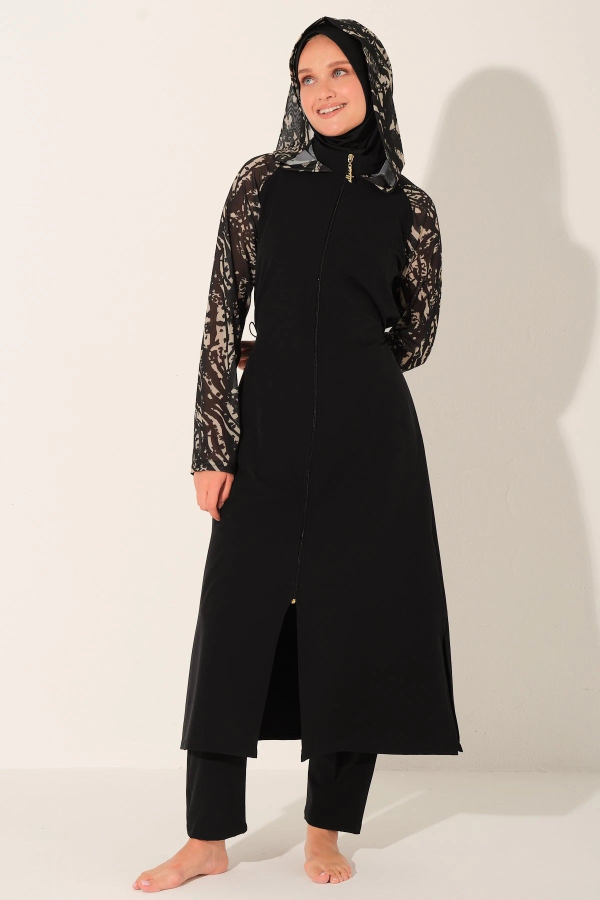 Black burkini set with patterned sleeves, model in a slight angle.