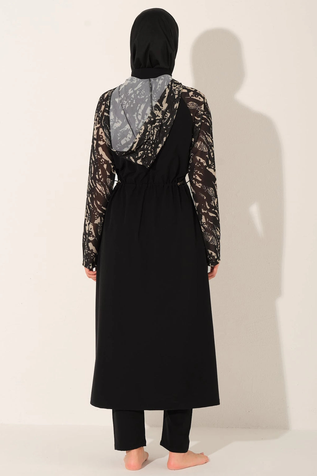 Black burkini set with patterned sleeves and hood, back view.