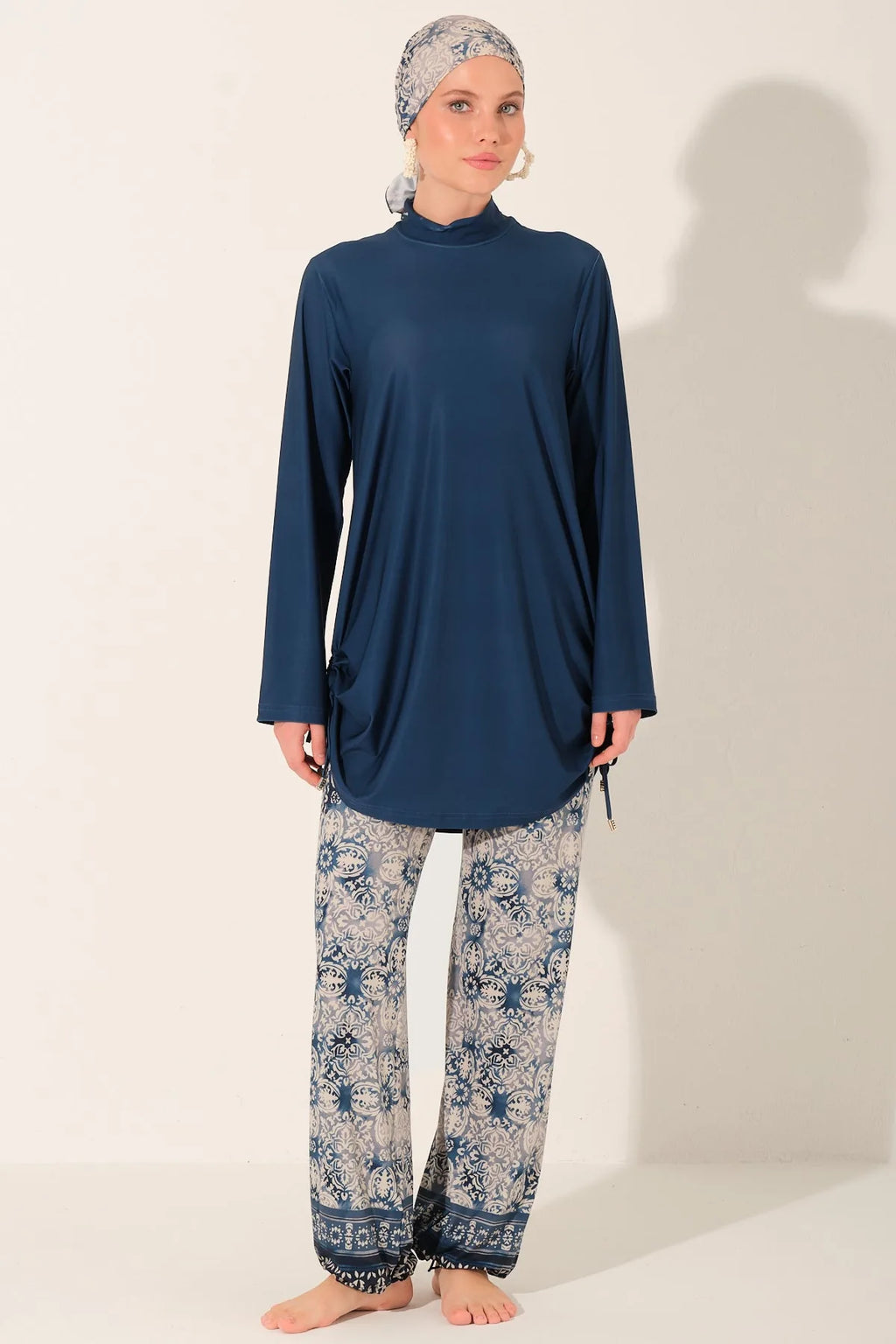 Full view of blue burkini swimwear with patterned pants and head covering.