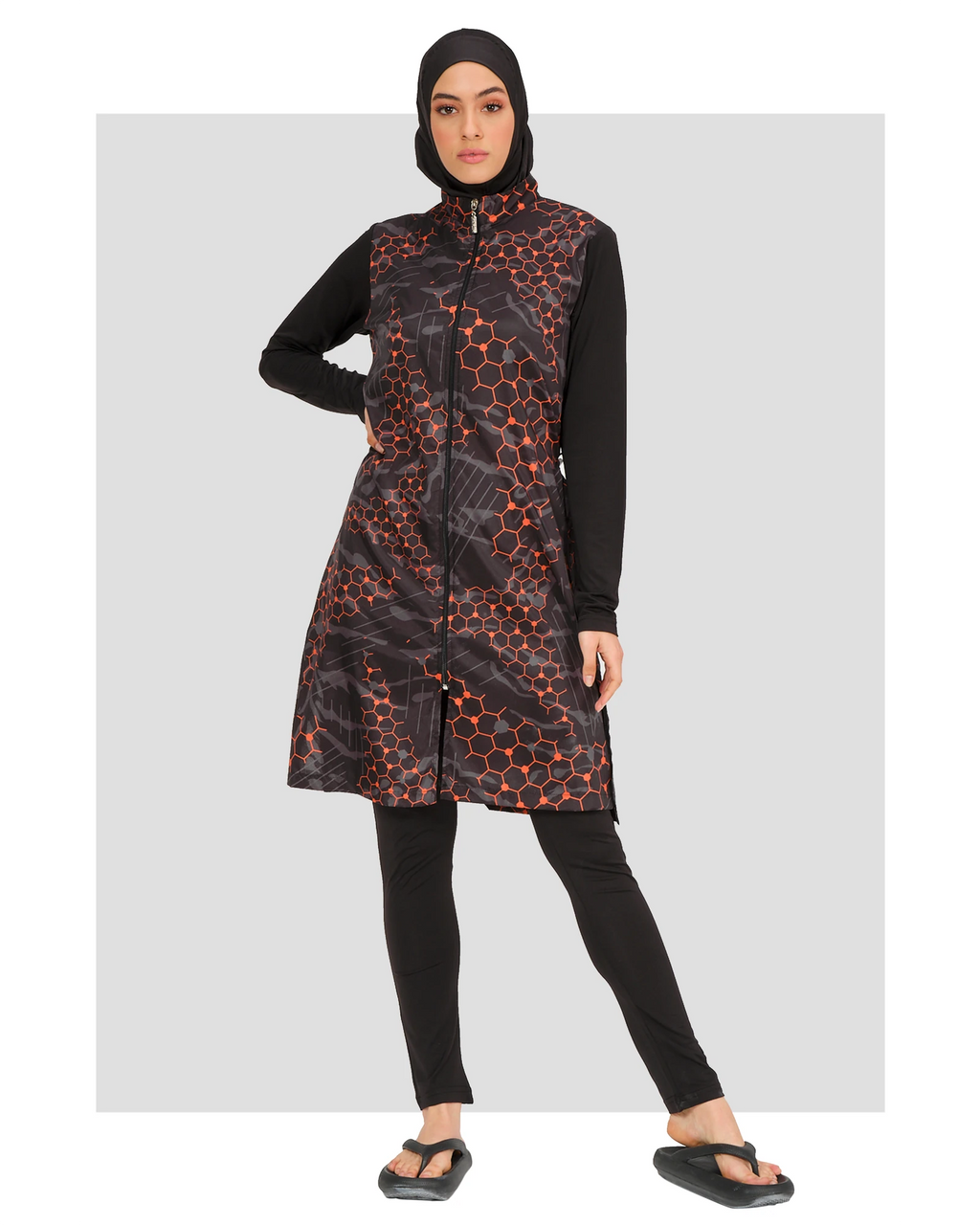 Model in orange and black patterned burkini set, front view, standing.