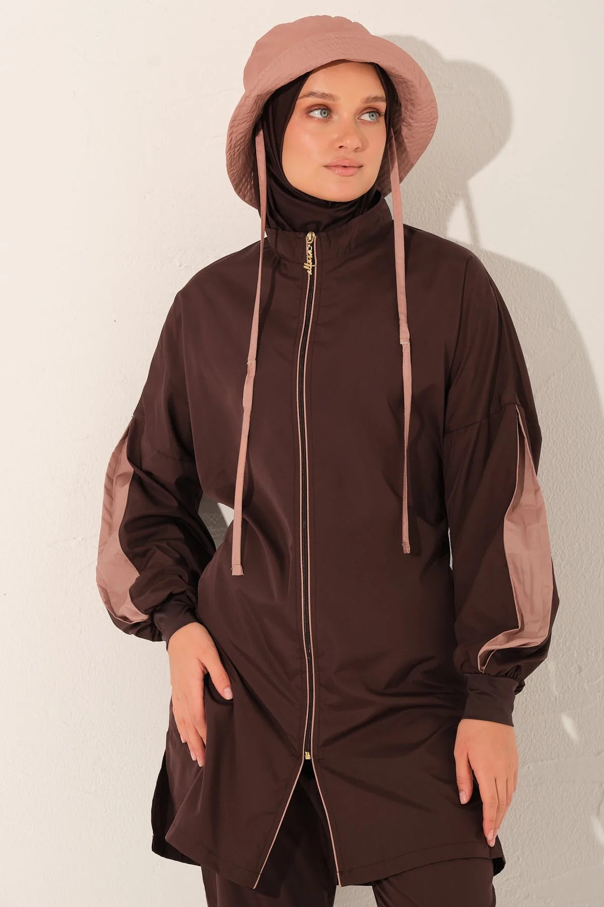 Close-up of mocha blush burkini top, hijab, and matching hat on model.
