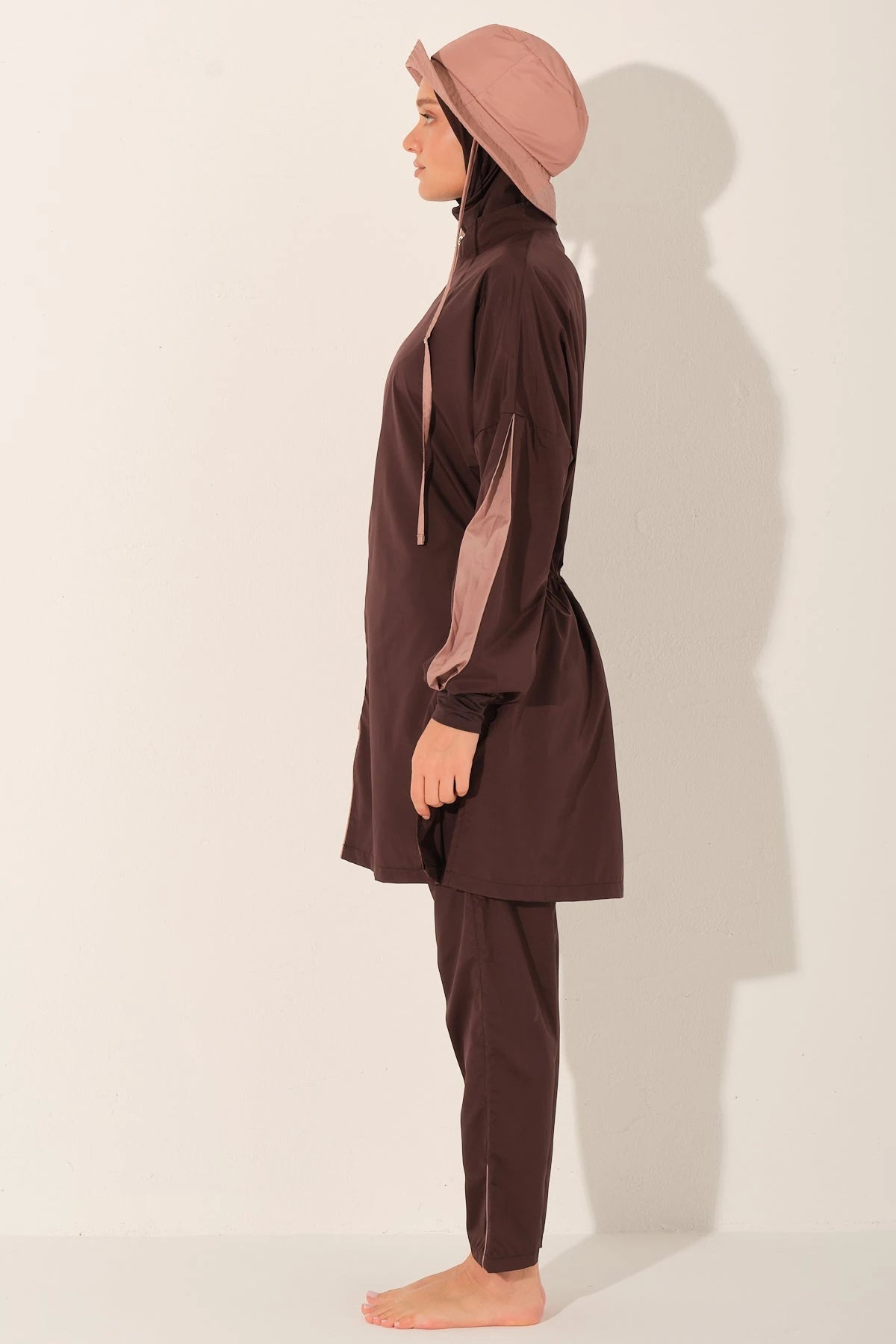 Side profile of model in mocha blush burkini set with hat.