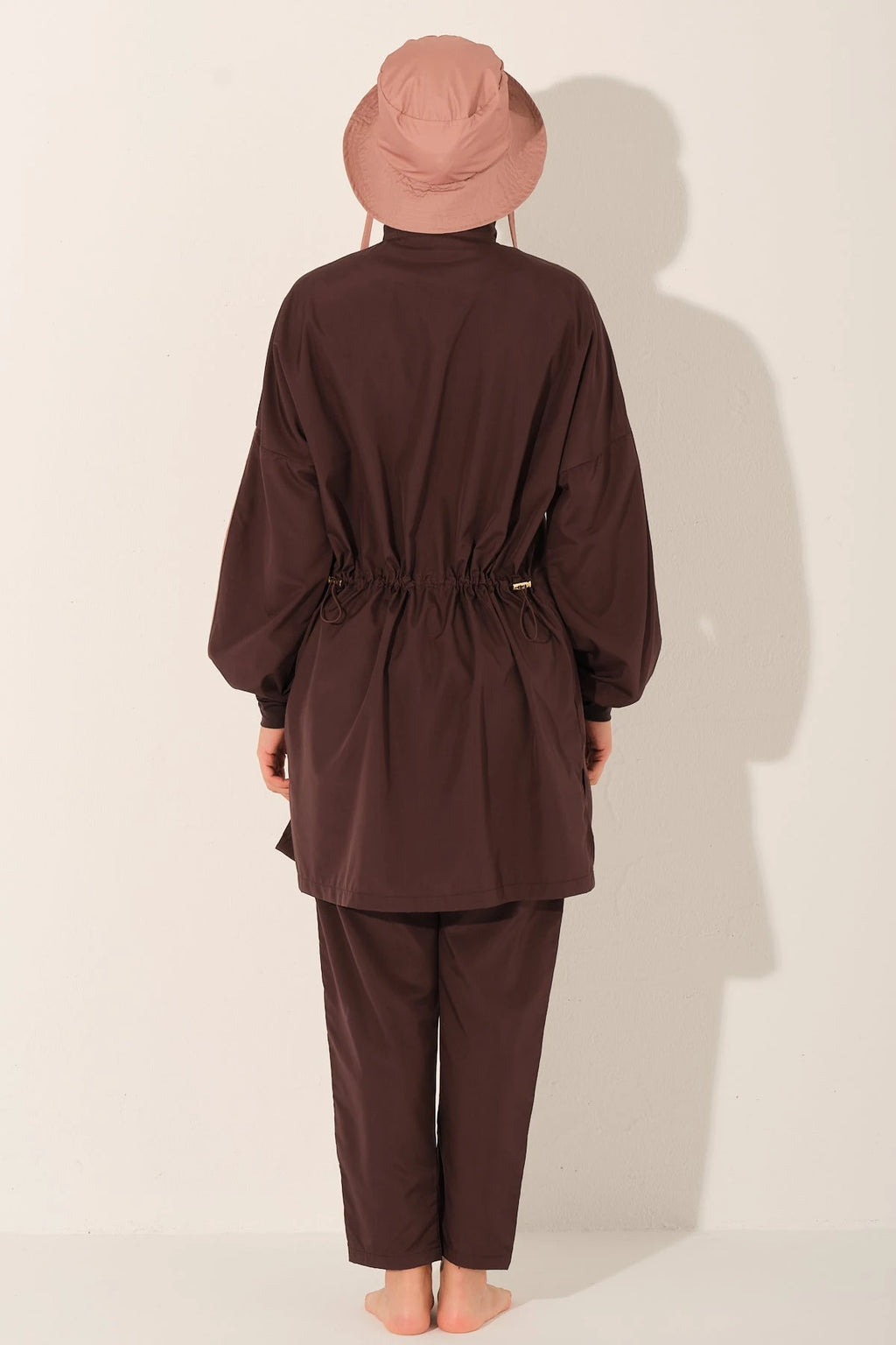 Back view of mocha blush burkini set on model, showing waist detail.