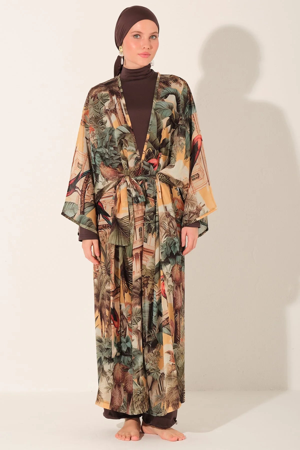 Woman wearing a long, patterned dress with a plain background