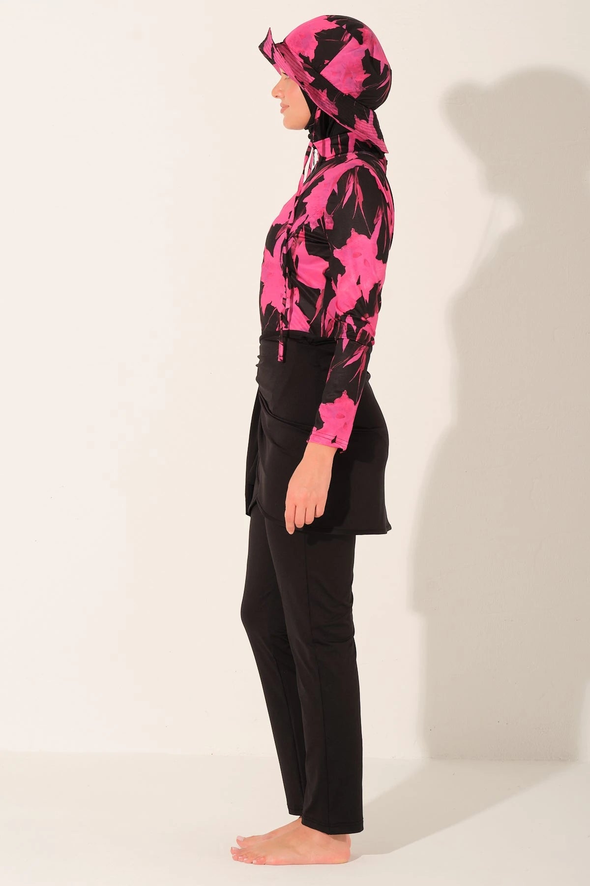 Woman wearing active floral burkini set, profile view.